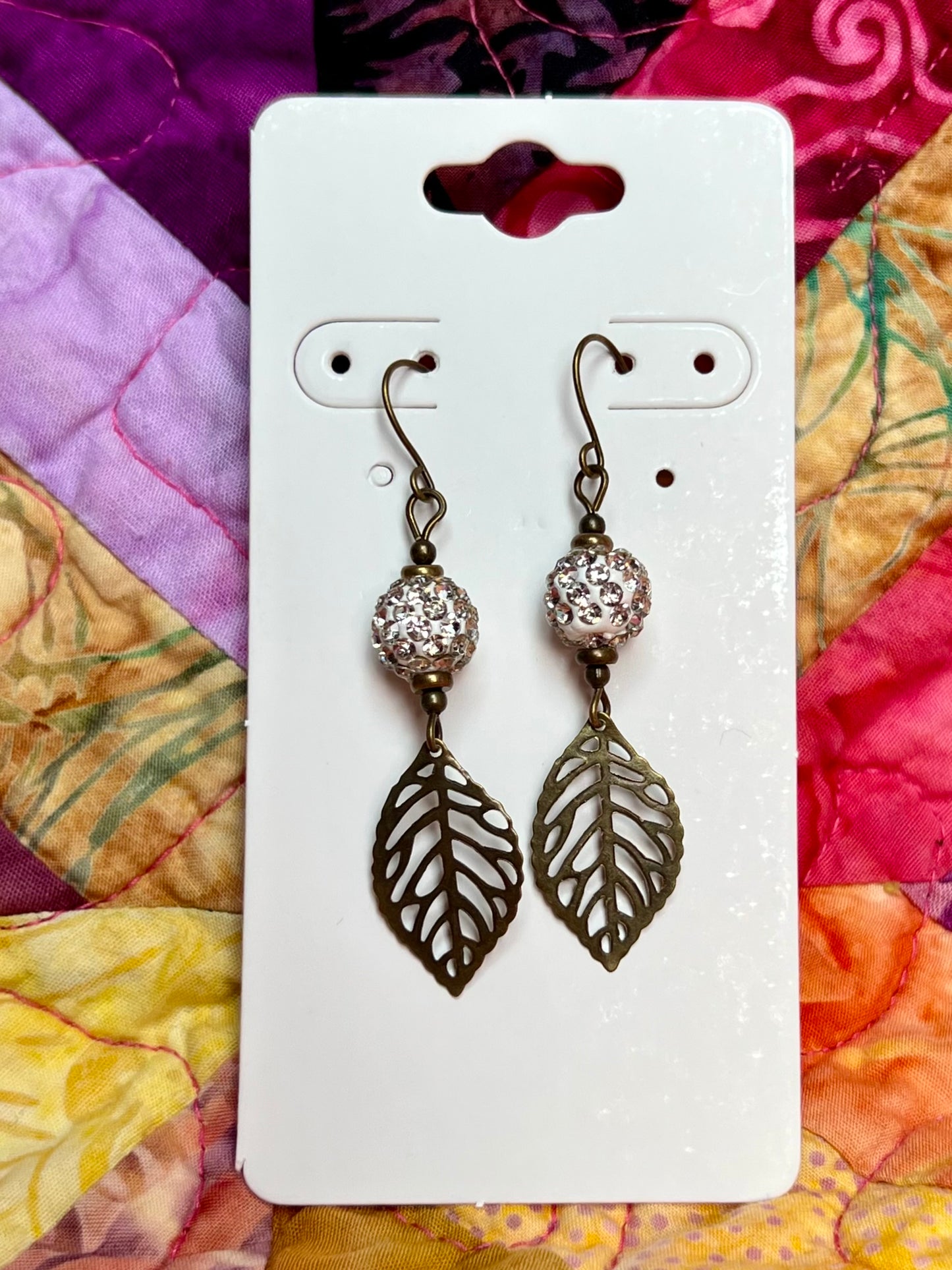 Earrings- Antique gold plated metal leaves with polymer clay beads with clear crystal rhinestones.