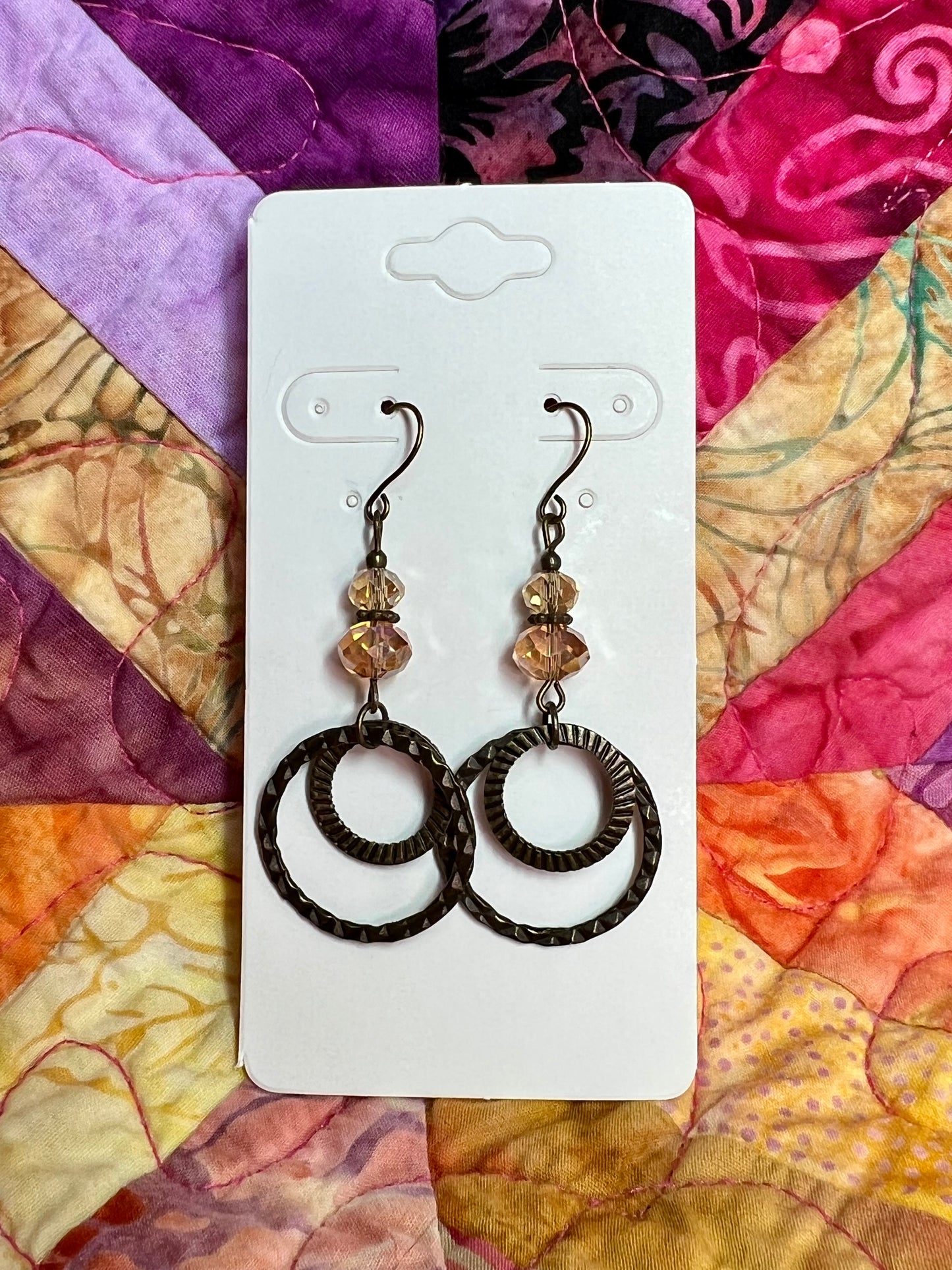 Earrings- Antique gold plated metal and iridescent orange luster coated crystals.