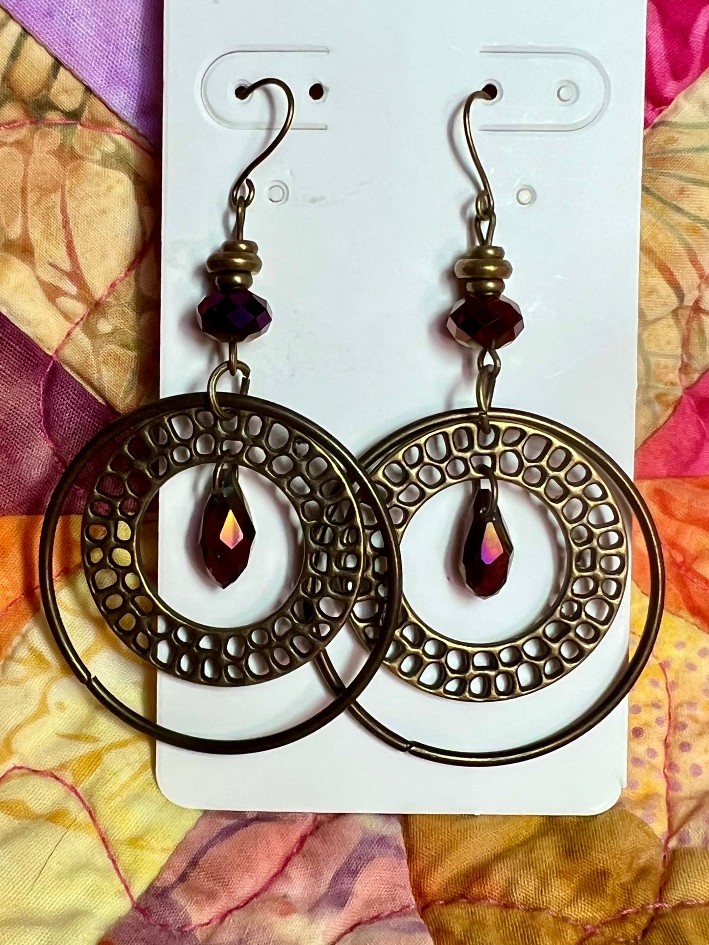 Earrings- Antique gold plated metal and crystal beads in a metallic purple coating.