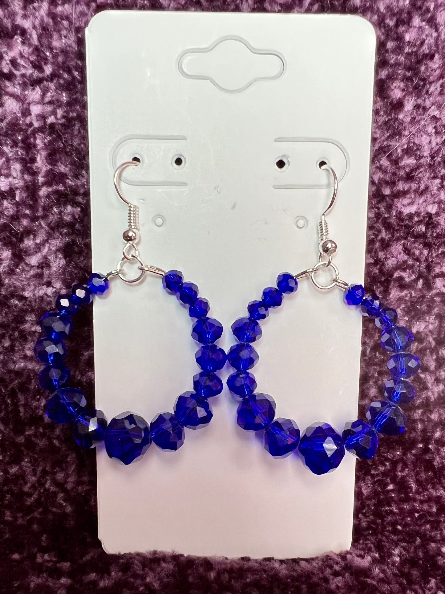 Earrings- Silver plated metal hoops with blue crystals.