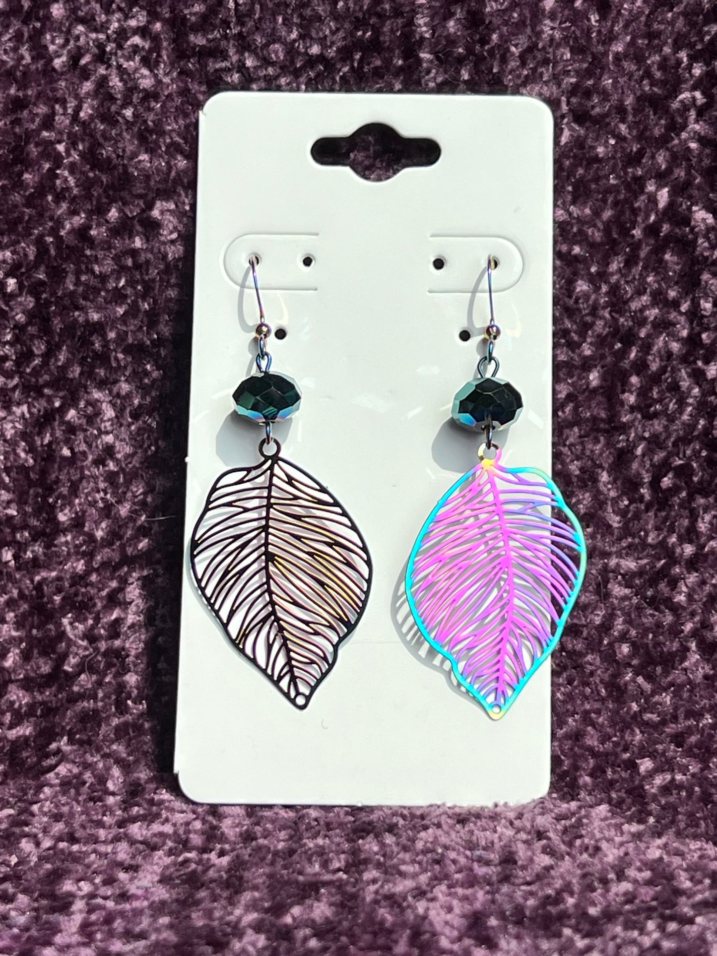 Earrings- Rainbow coated stainless steel leaves and ear wires with metallic green crystal beads.