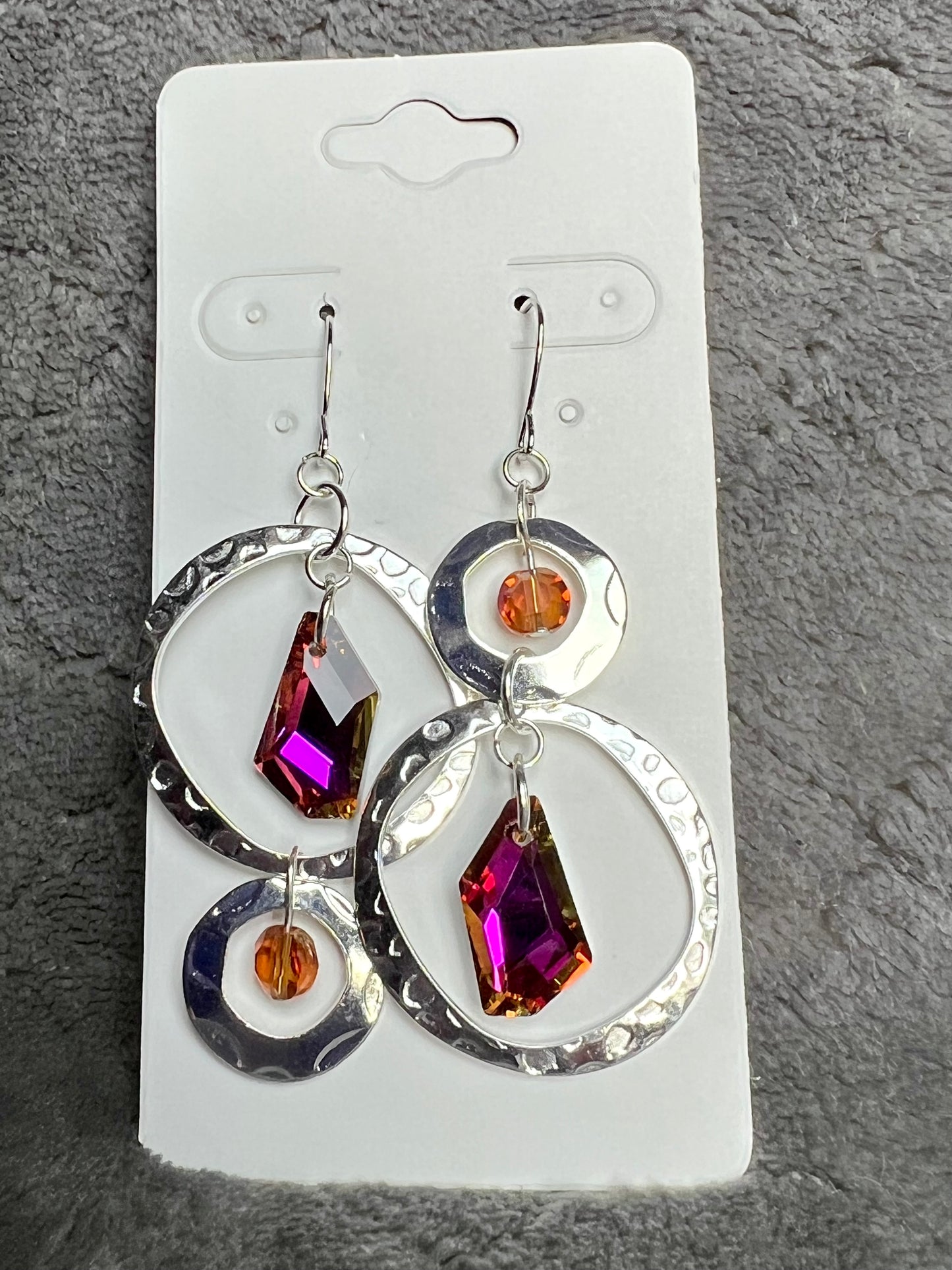 Earrings- Asymmetrical silver plated metal with orange/copper AB and foil backed magenta crystals.