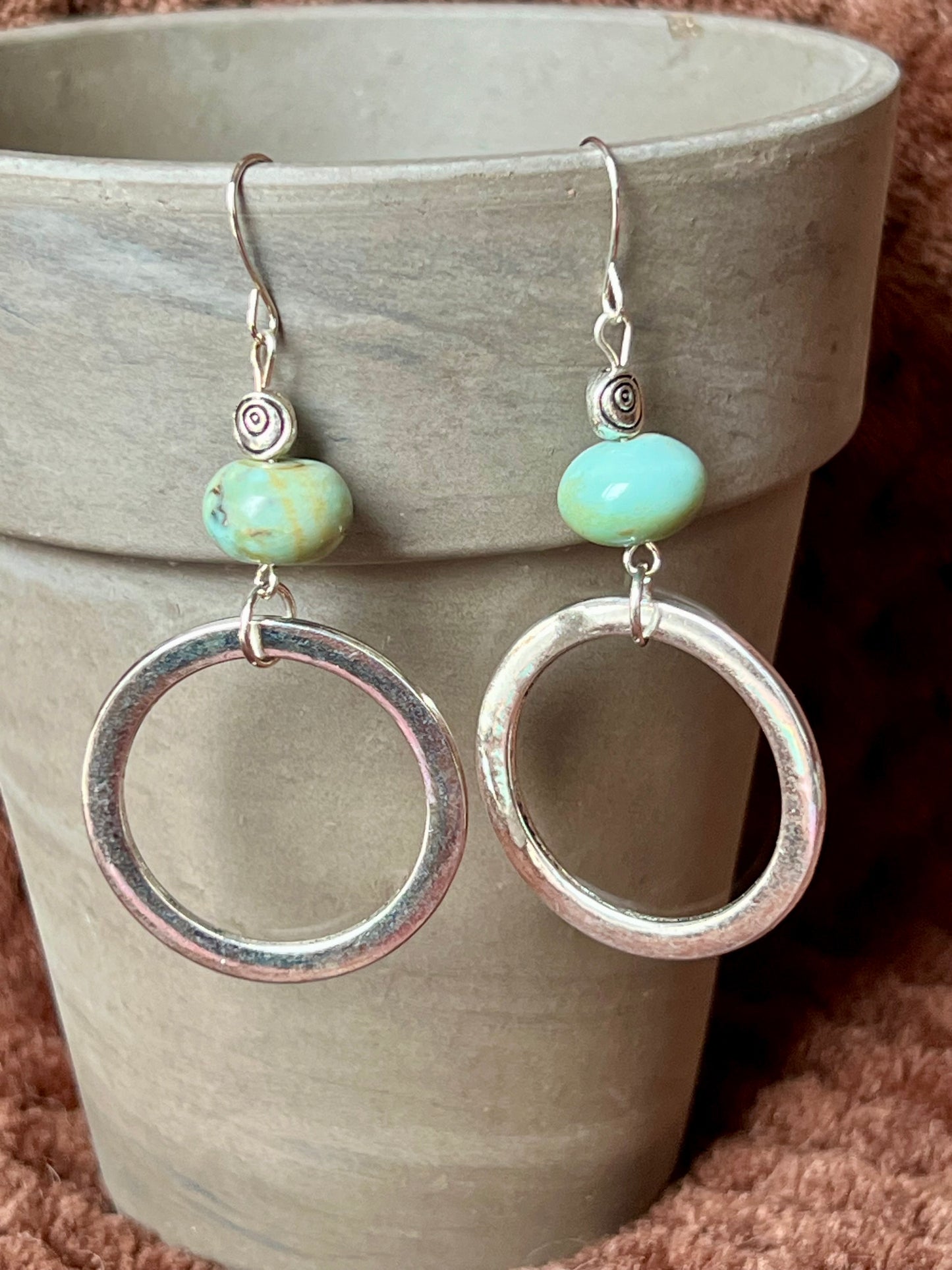 Earrings- Silver plated metal with natural stone beads on top of antiqued silver plated hoops.