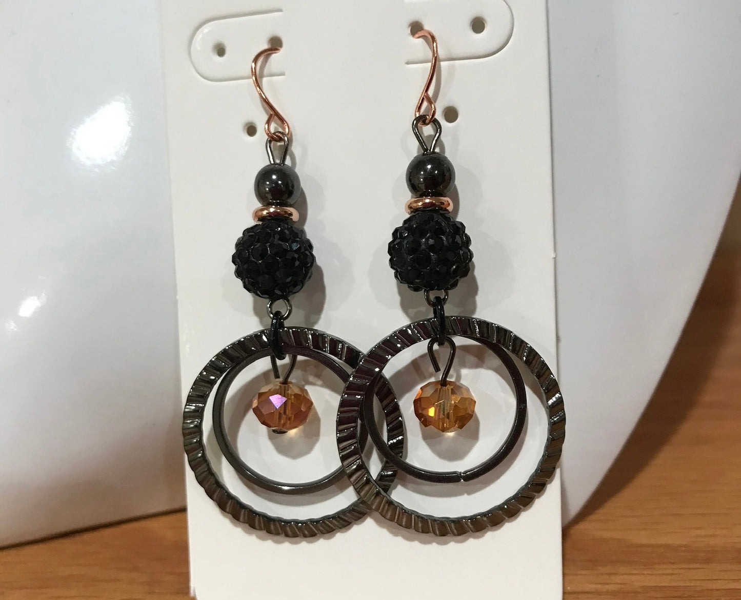 Earrings- Gun metal with copper plated ear wires & iridescent orange satin crystal.