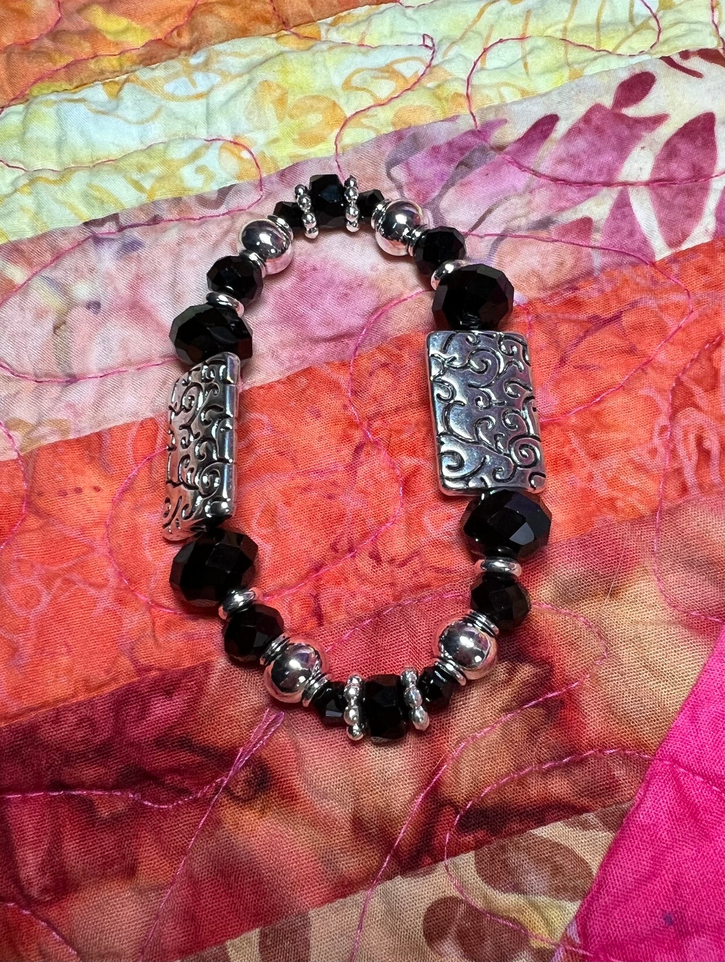 Bracelet- Silver plated metal beads with opaque black crystals.