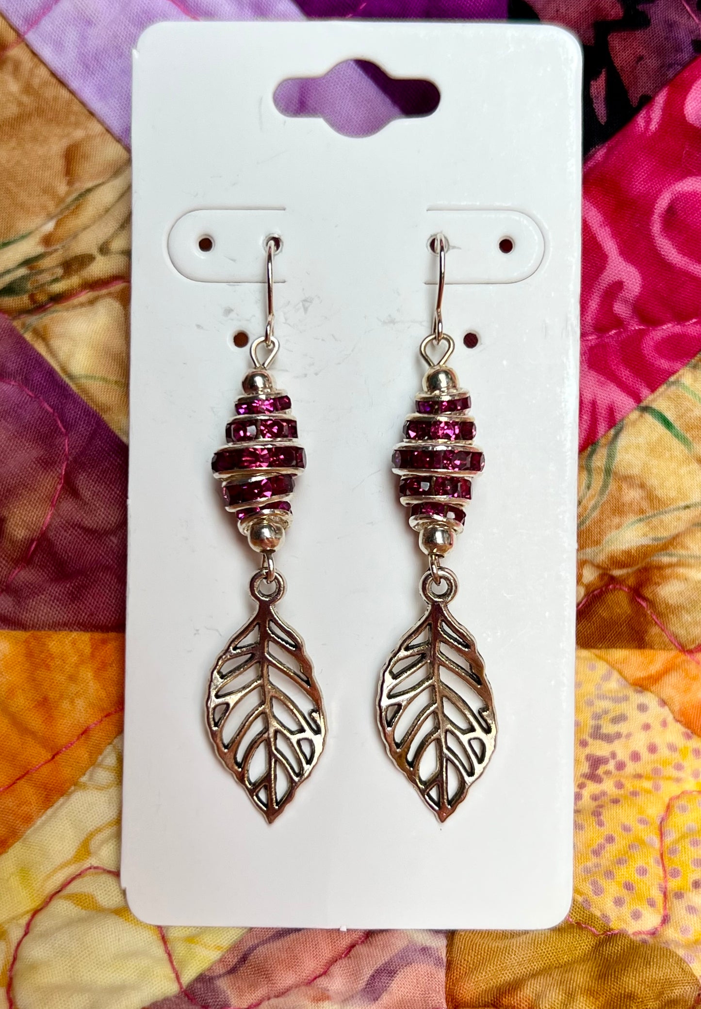 Earrings- Silver plated metal leaves with fuchsia colored crystal rondelles.