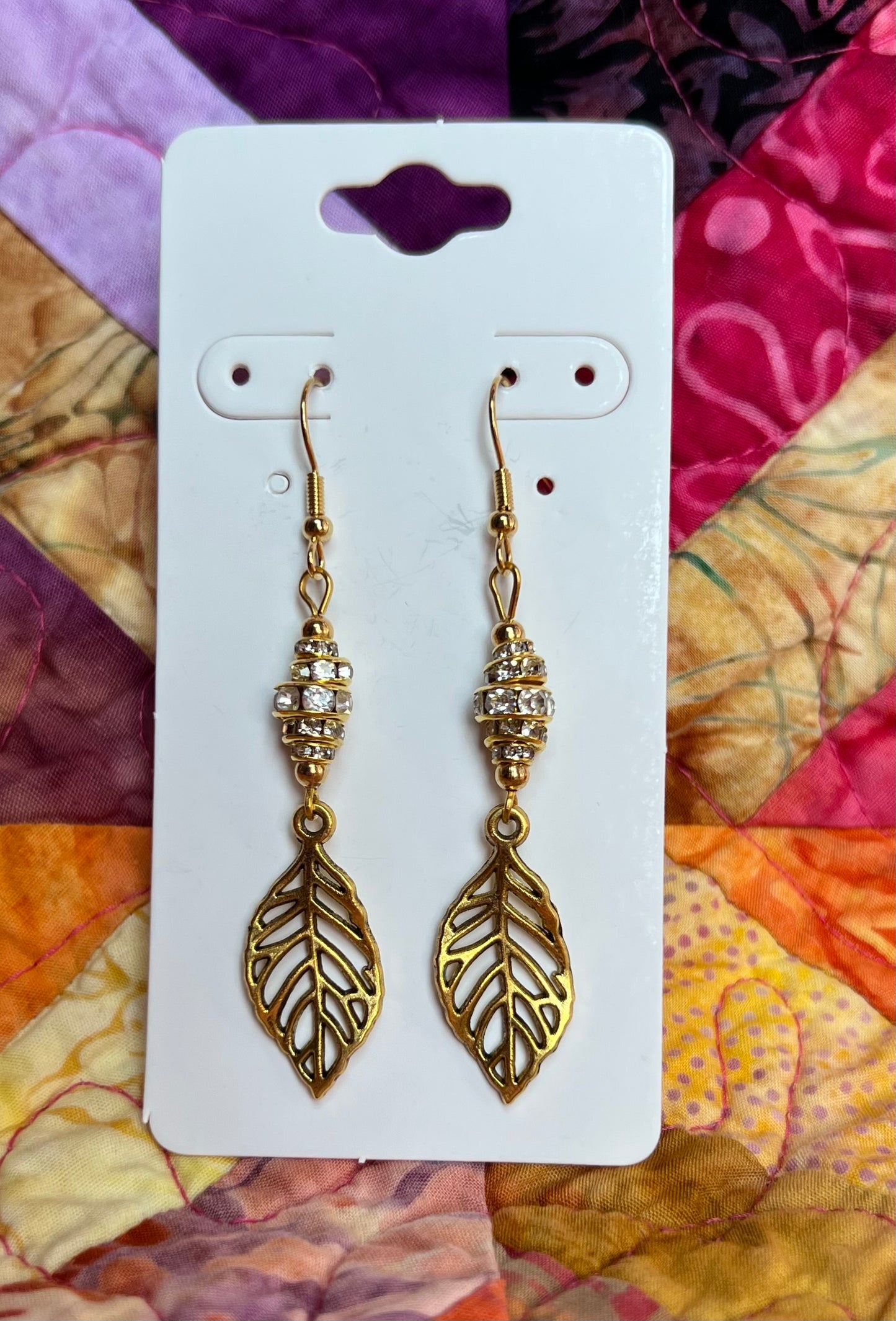 Earrings- Gold plated metal leaves with clear crystal rondelles.