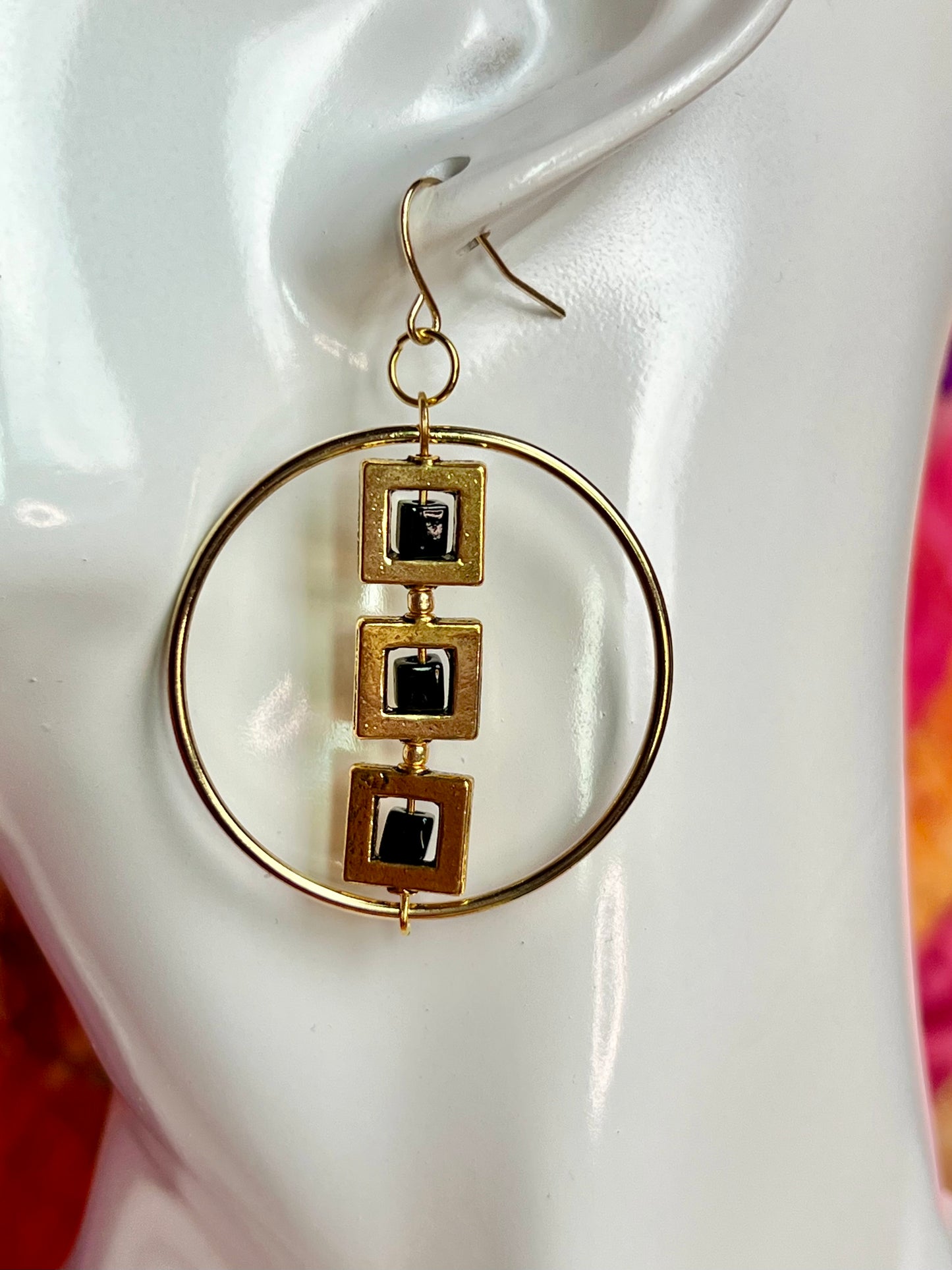 Earrings- Gold plated metal hoops with squares and black cube seed beads.