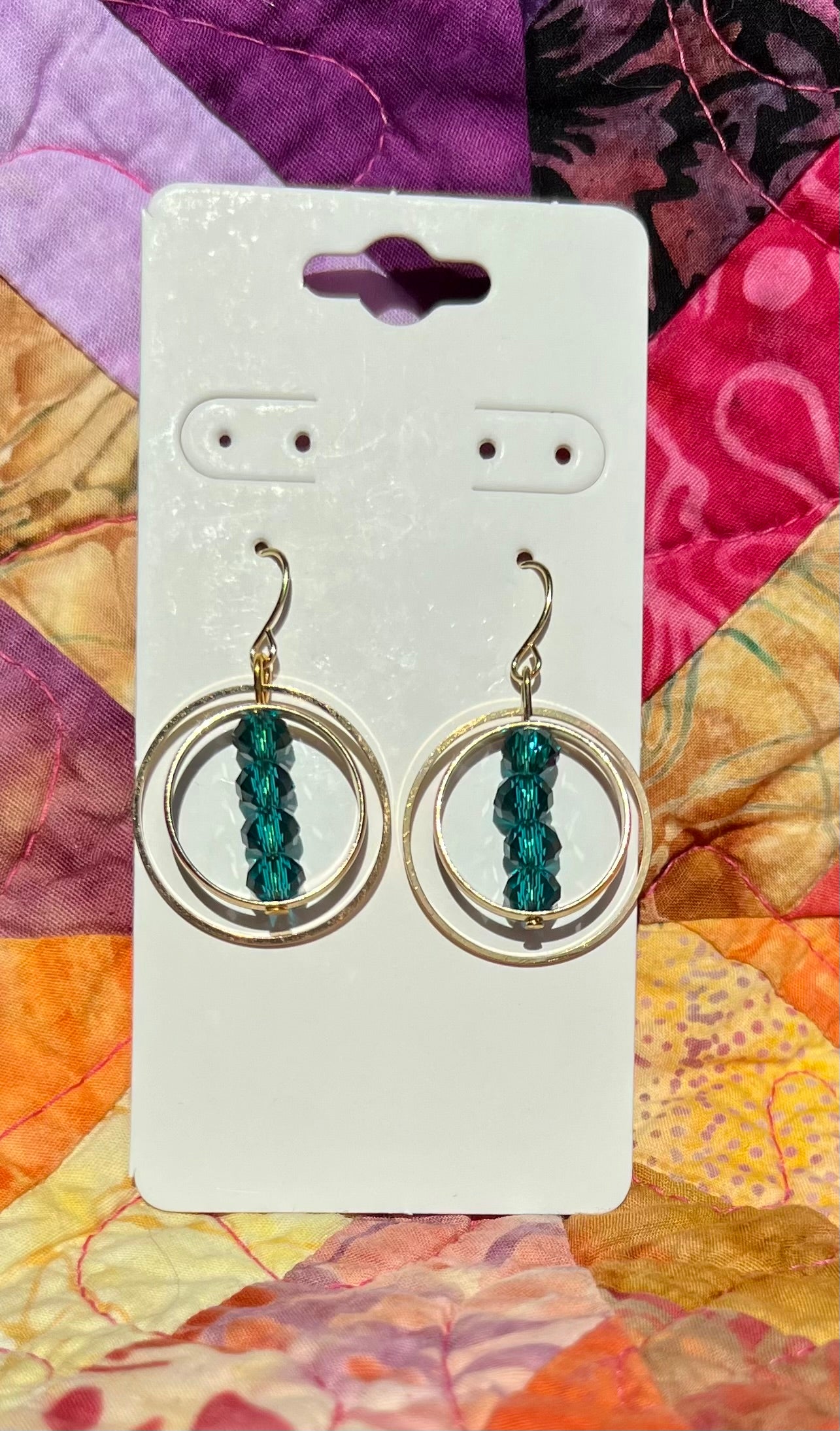 Earrings- Gold plated metal with teal colored crystals.