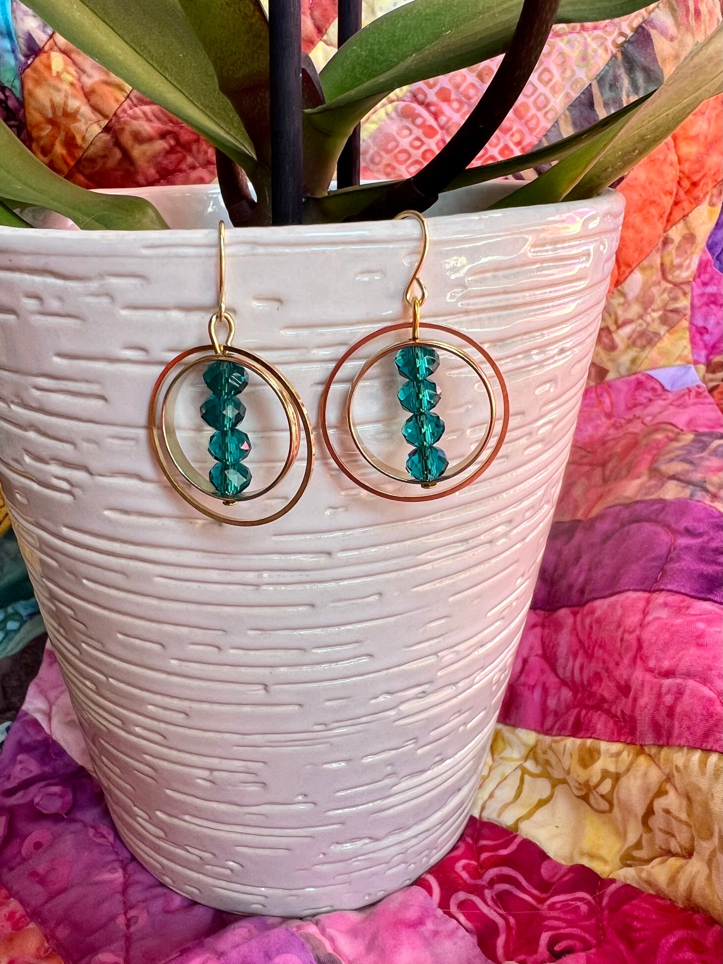 Earrings- Gold plated metal with teal colored crystals.