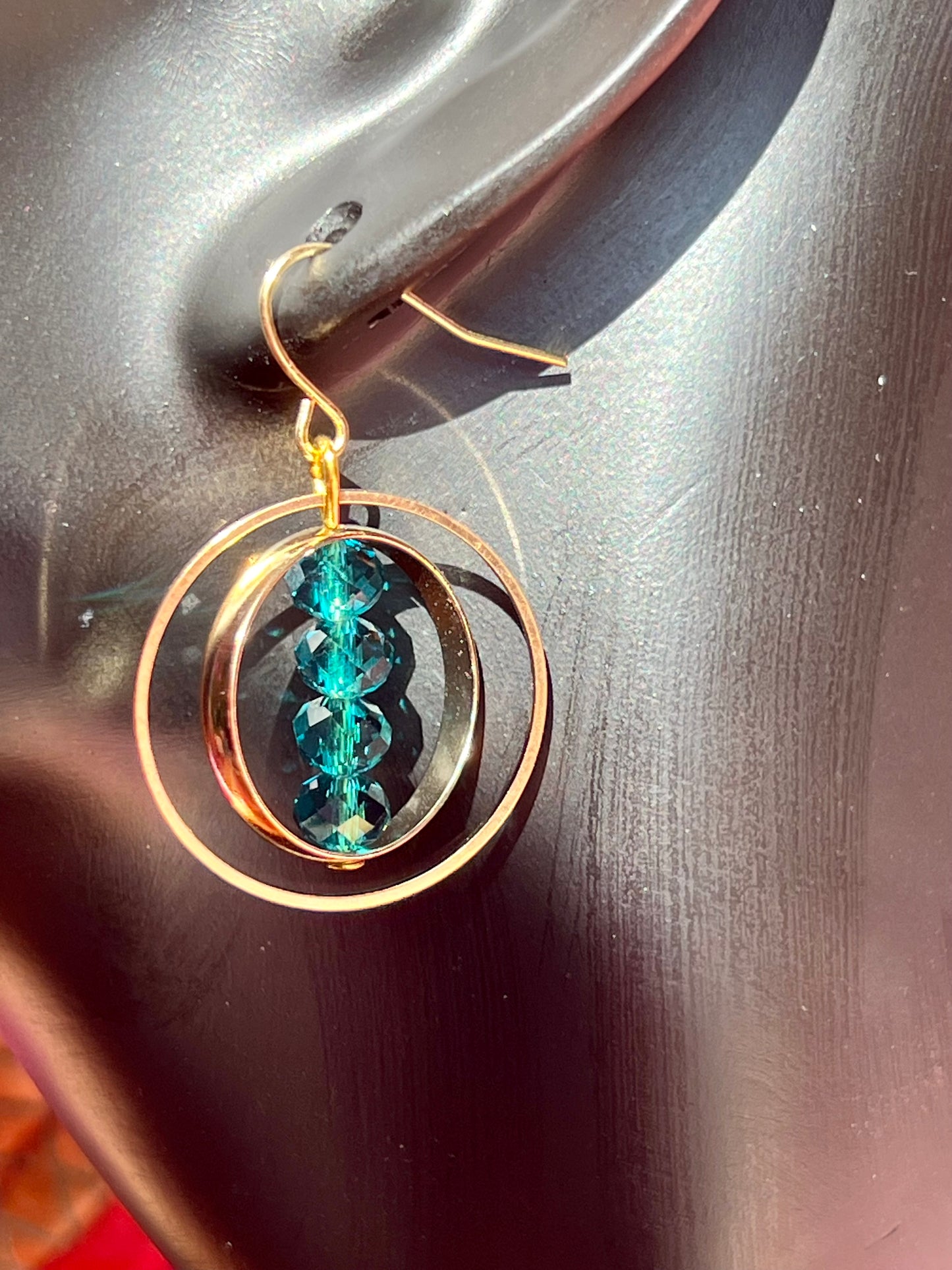 Earrings- Gold plated metal with teal colored crystals.