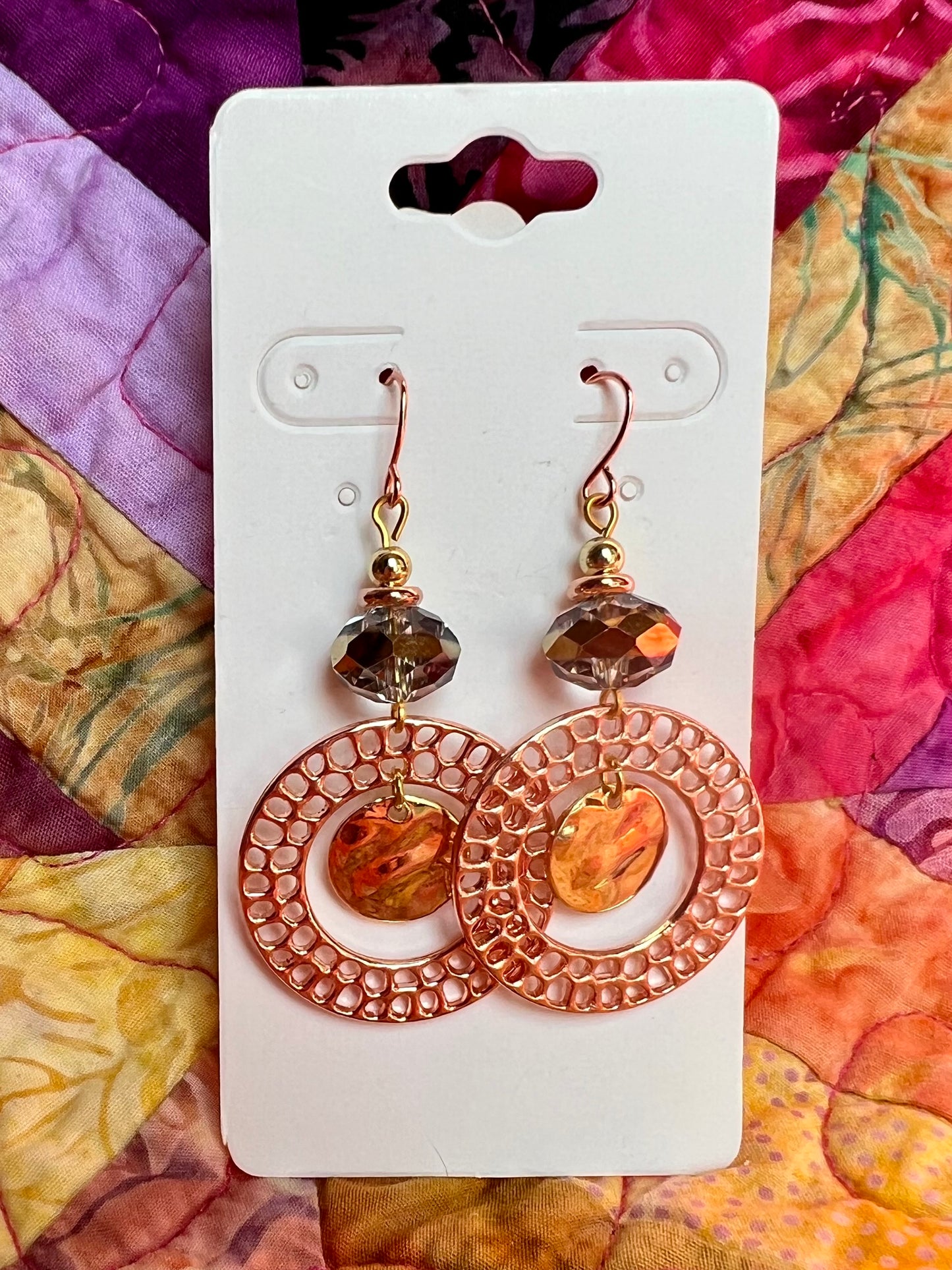 Earrings- Copper and gold plated metal and a clear crystal with a gold stripe in the center.