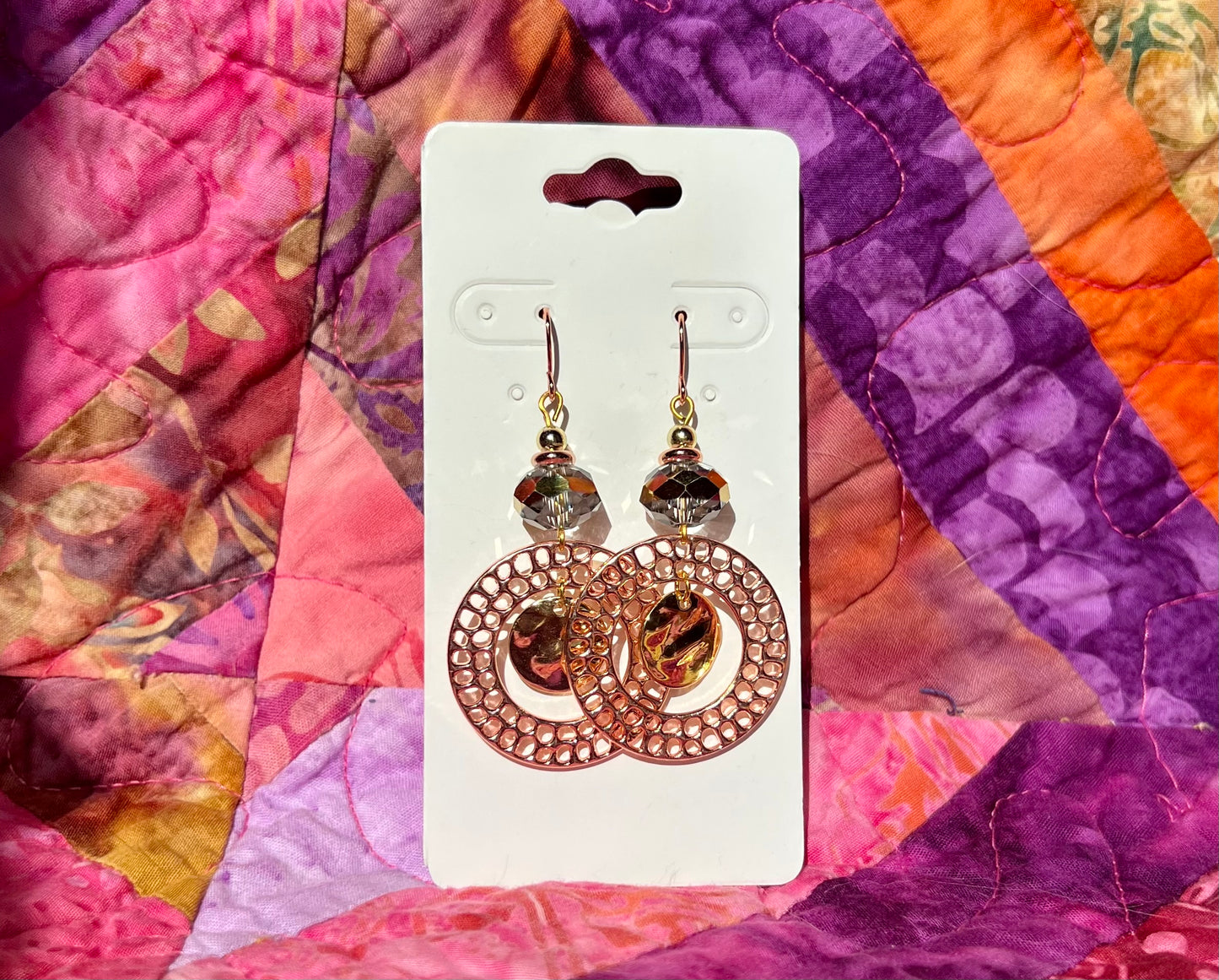 Earrings- Copper and gold plated metal and a clear crystal with a gold stripe in the center.