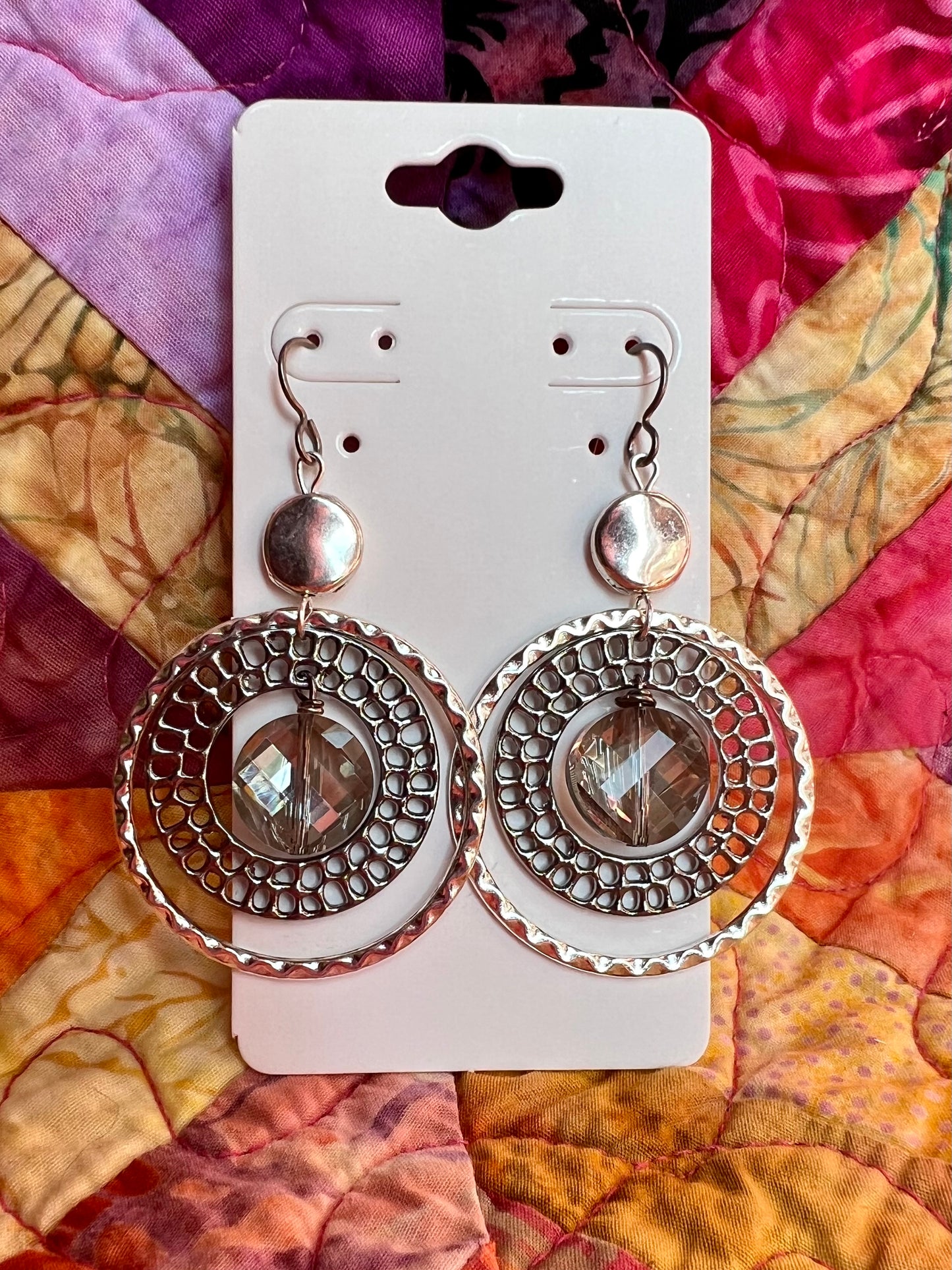 Earrings- Titanium ear hooks with silver and gunmetal plated metal paired with a coin shaped crystal.