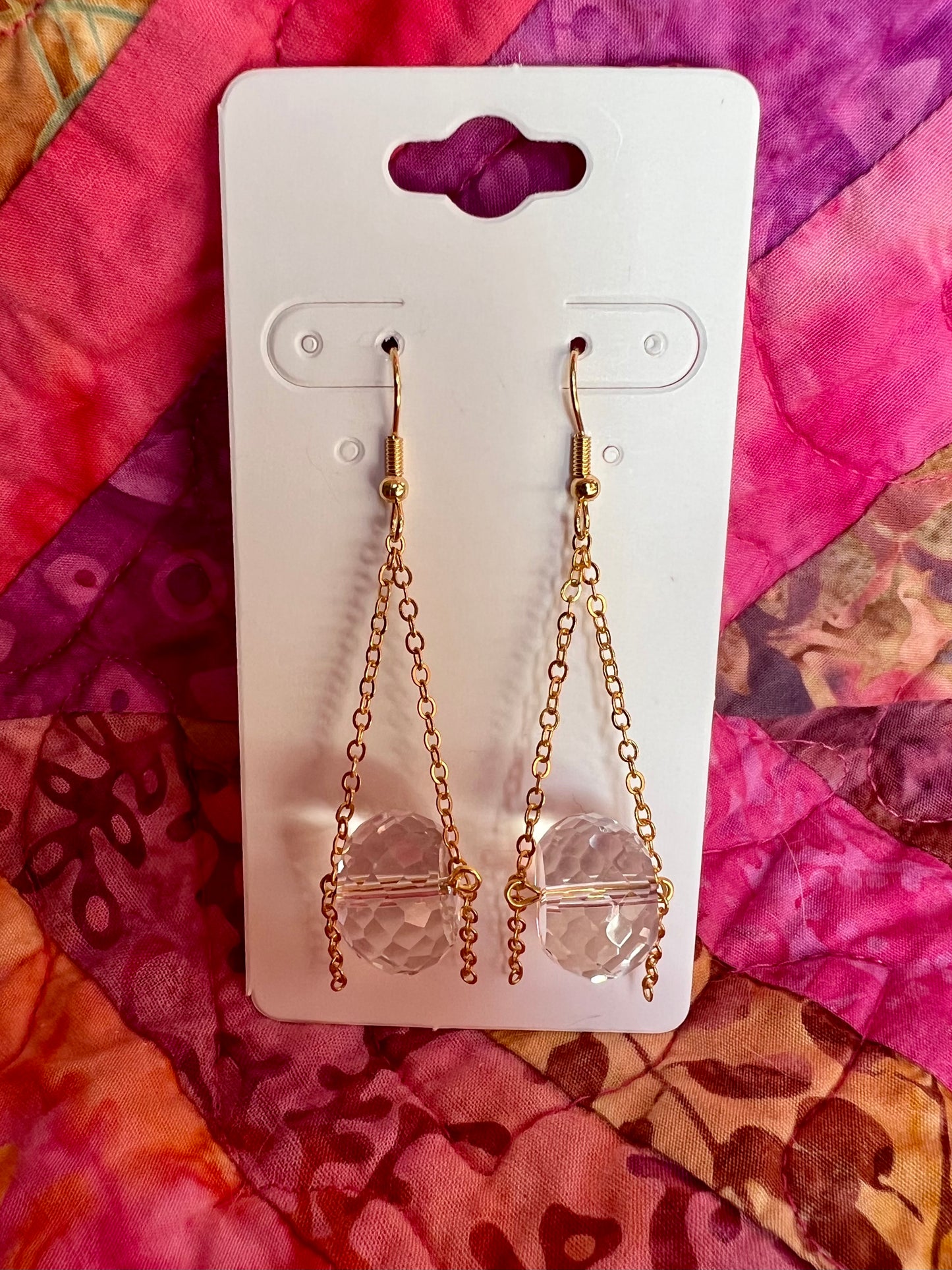 Earrings- Gold plated metal and chain with large clear crystals dangling on the bottom.