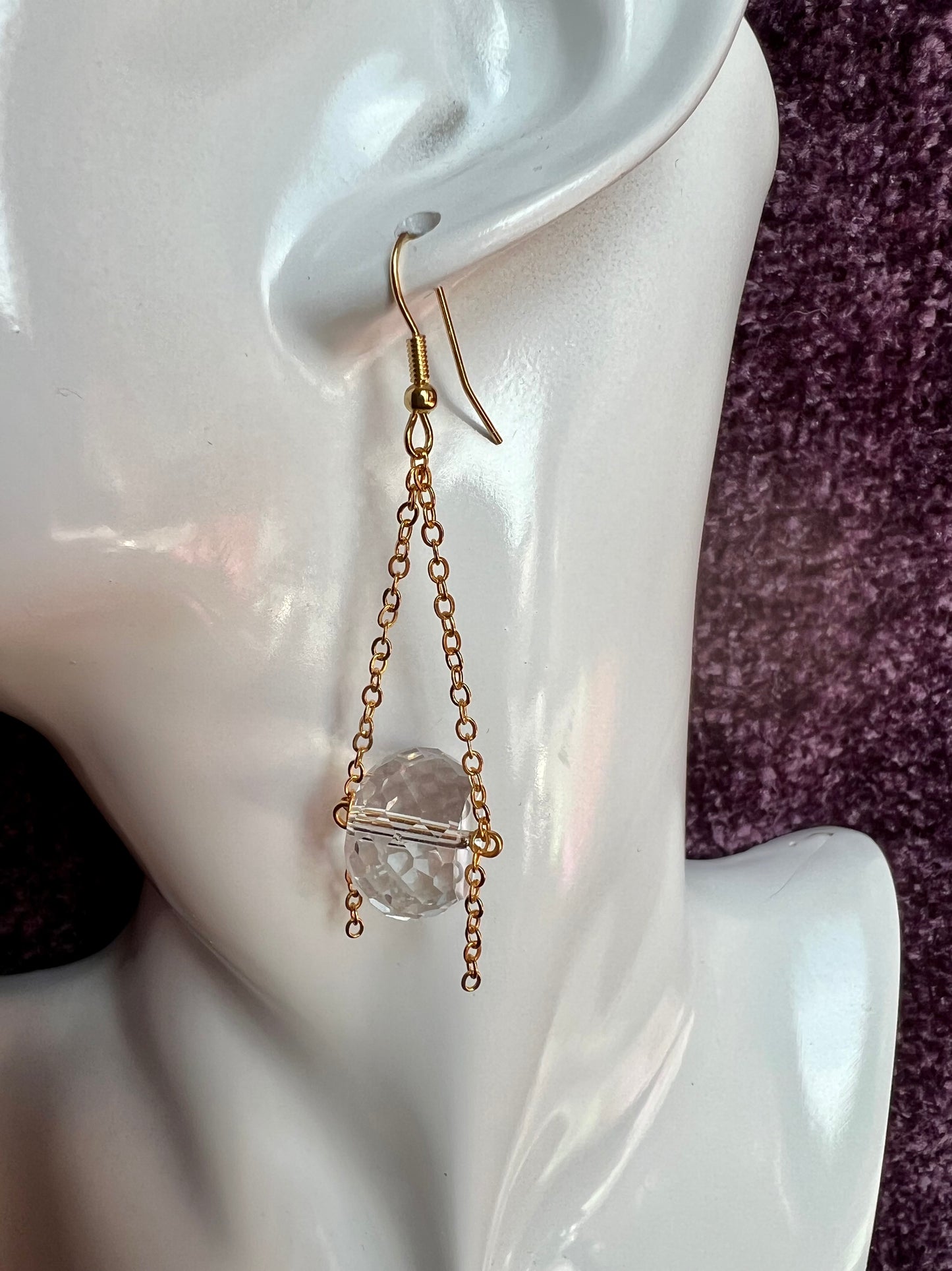 Earrings- Gold plated metal and chain with large clear crystals dangling on the bottom.