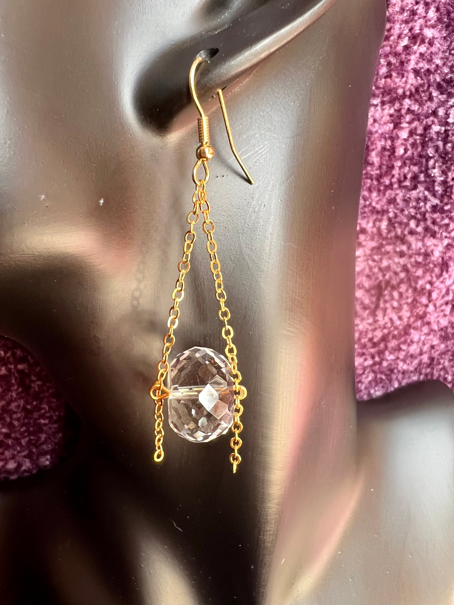 Earrings- Gold plated metal and chain with large clear crystals dangling on the bottom.