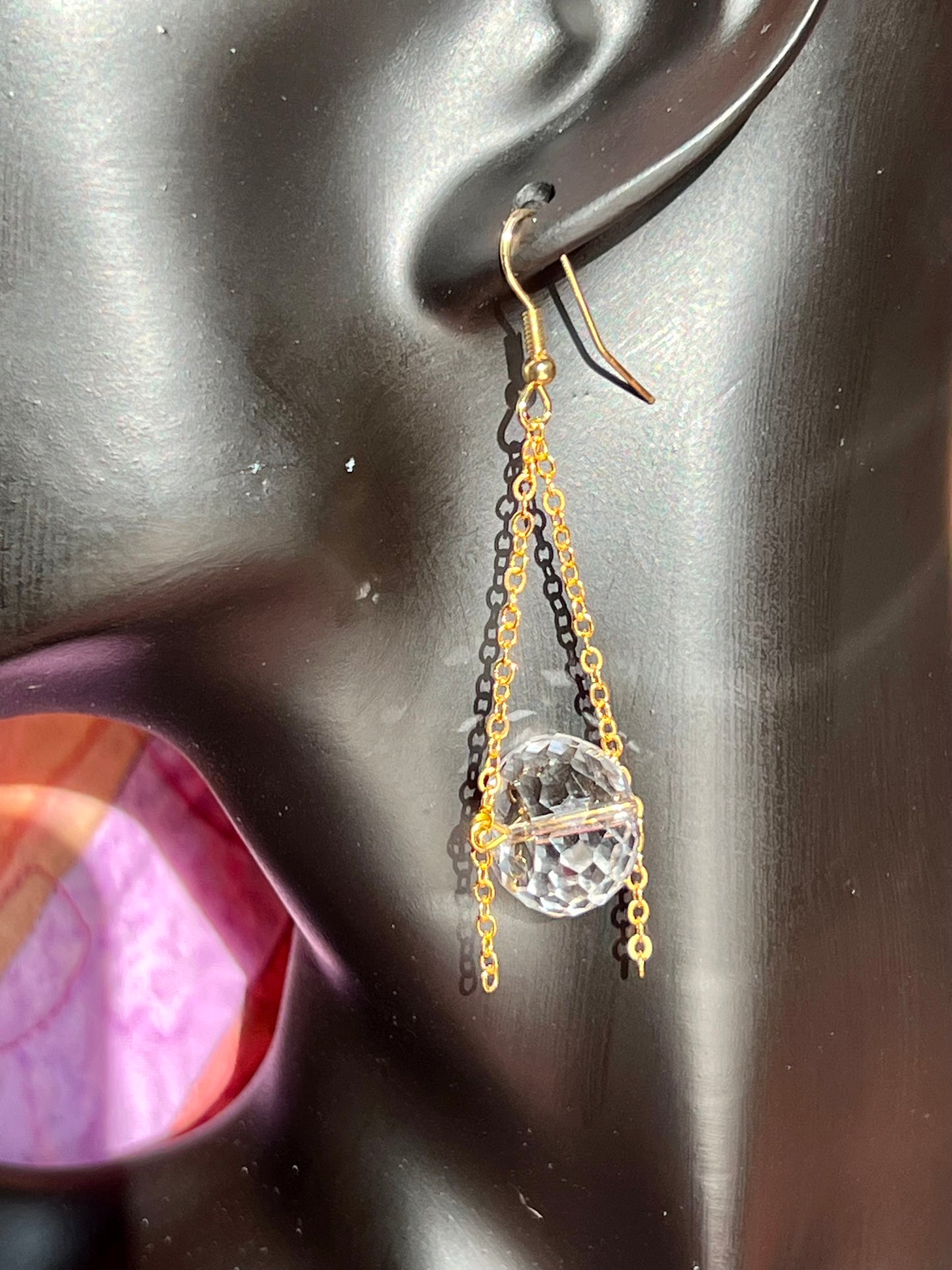 Earrings- Gold plated metal and chain with large clear crystals dangling on the bottom.