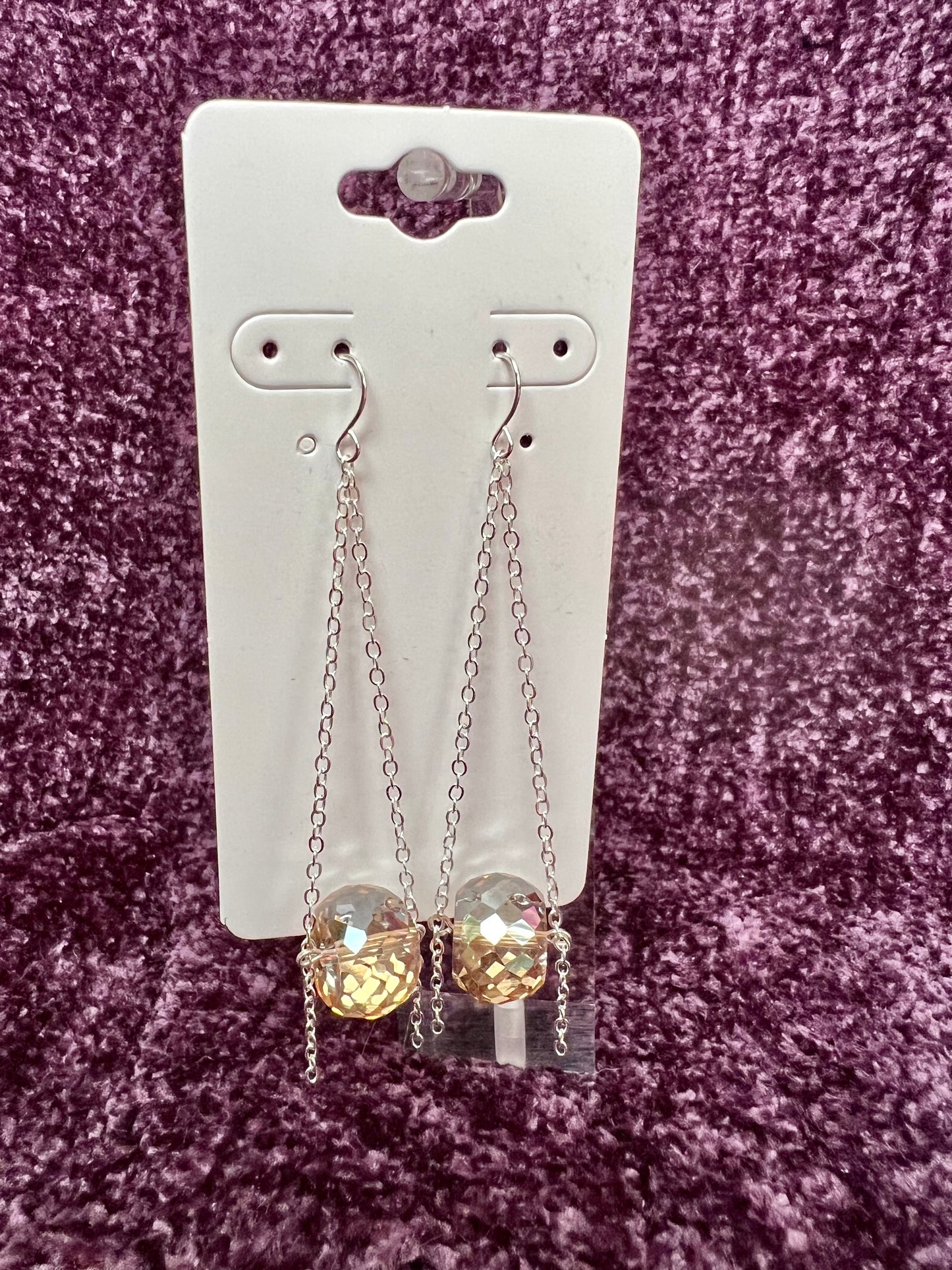 Earrings- Silver plated ear hooks, eye pins, and chain with champagne colored crystals.