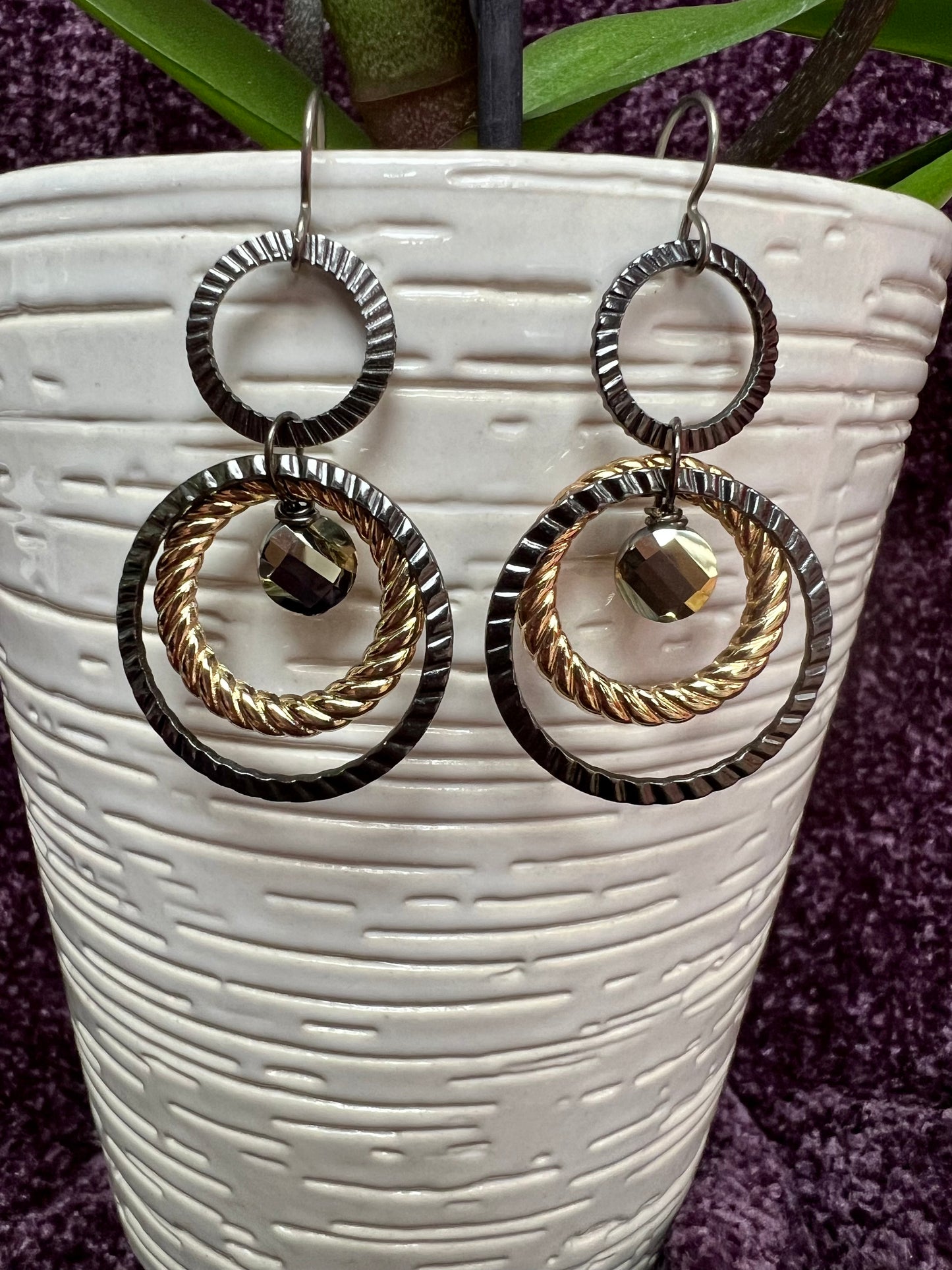 Earrings- Titanium ear hooks with gunmetal and gold plated metal hoops with unique crystals.