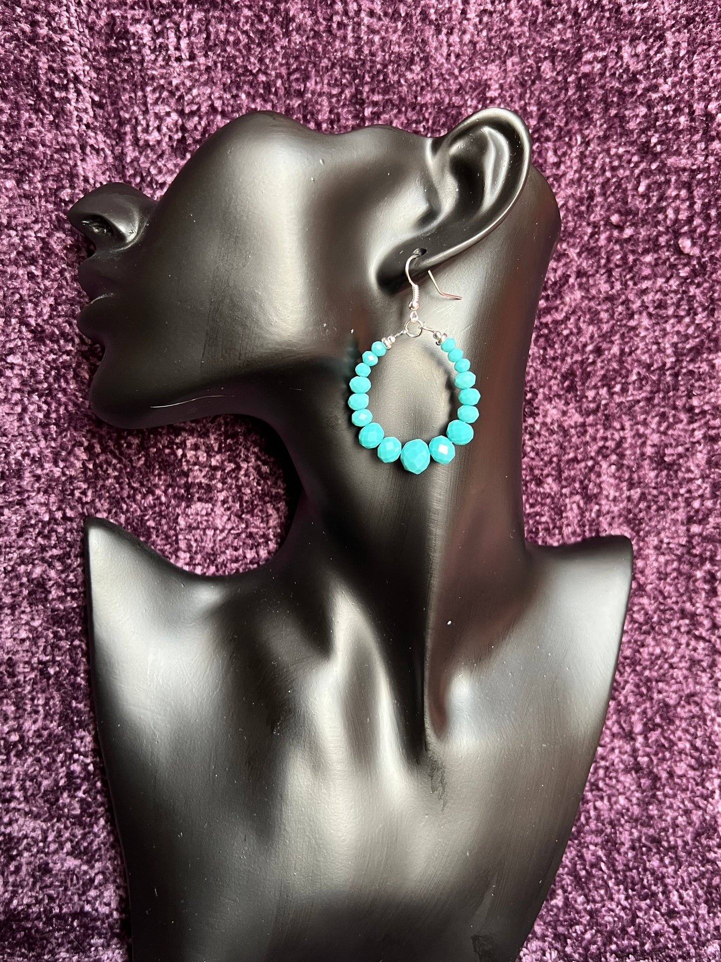 Earrings- Silver plated metal hoops with opaque turquoise colored crystals.
