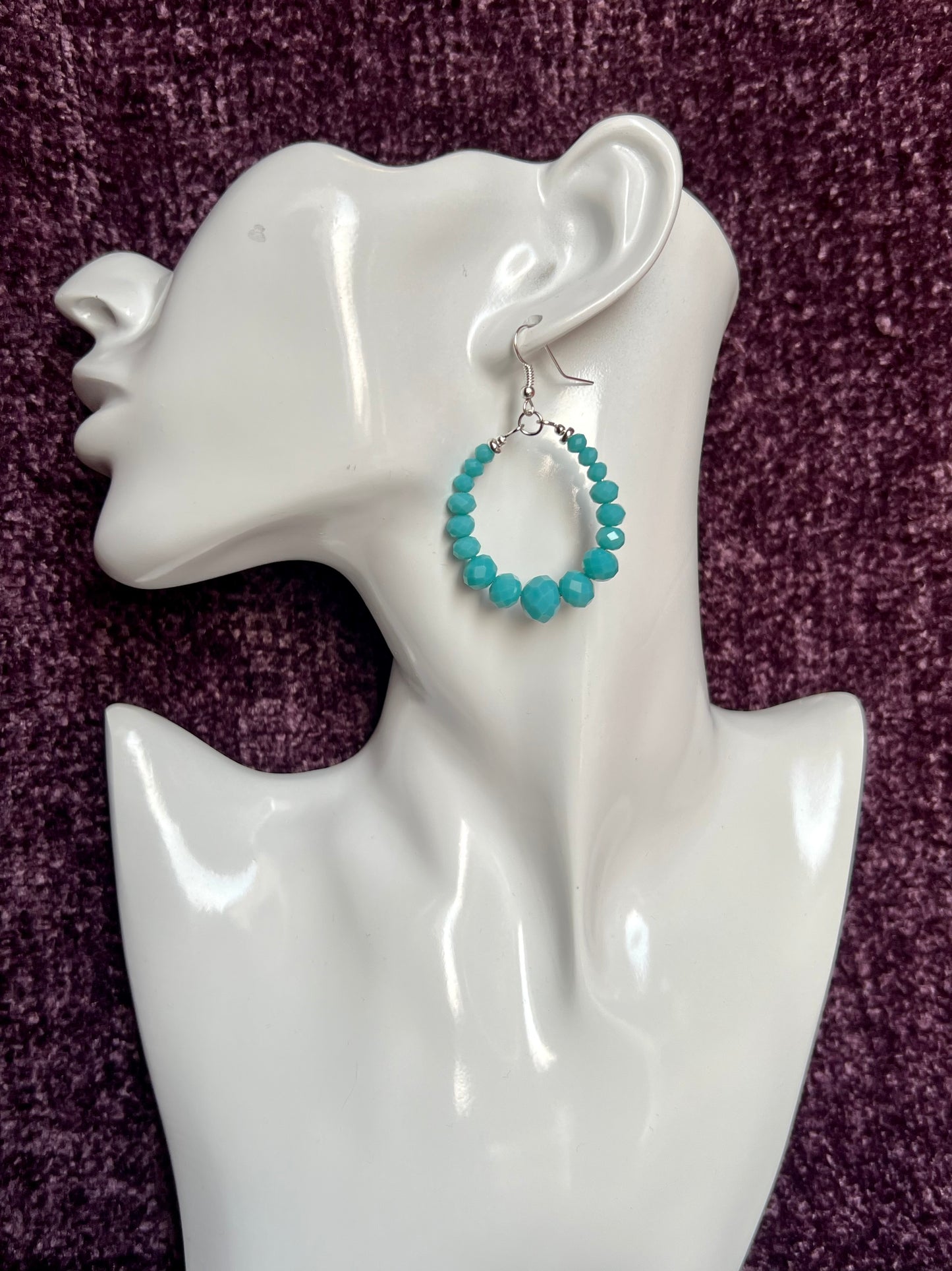 Earrings- Silver plated metal hoops with opaque turquoise colored crystals.