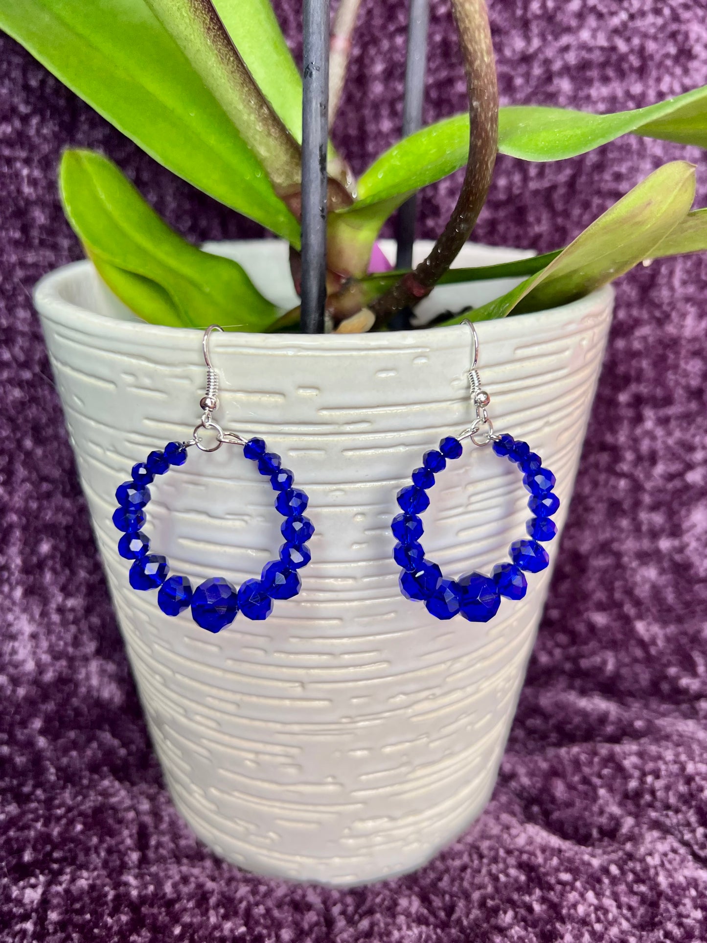 Earrings- Silver plated metal hoops with blue crystals.