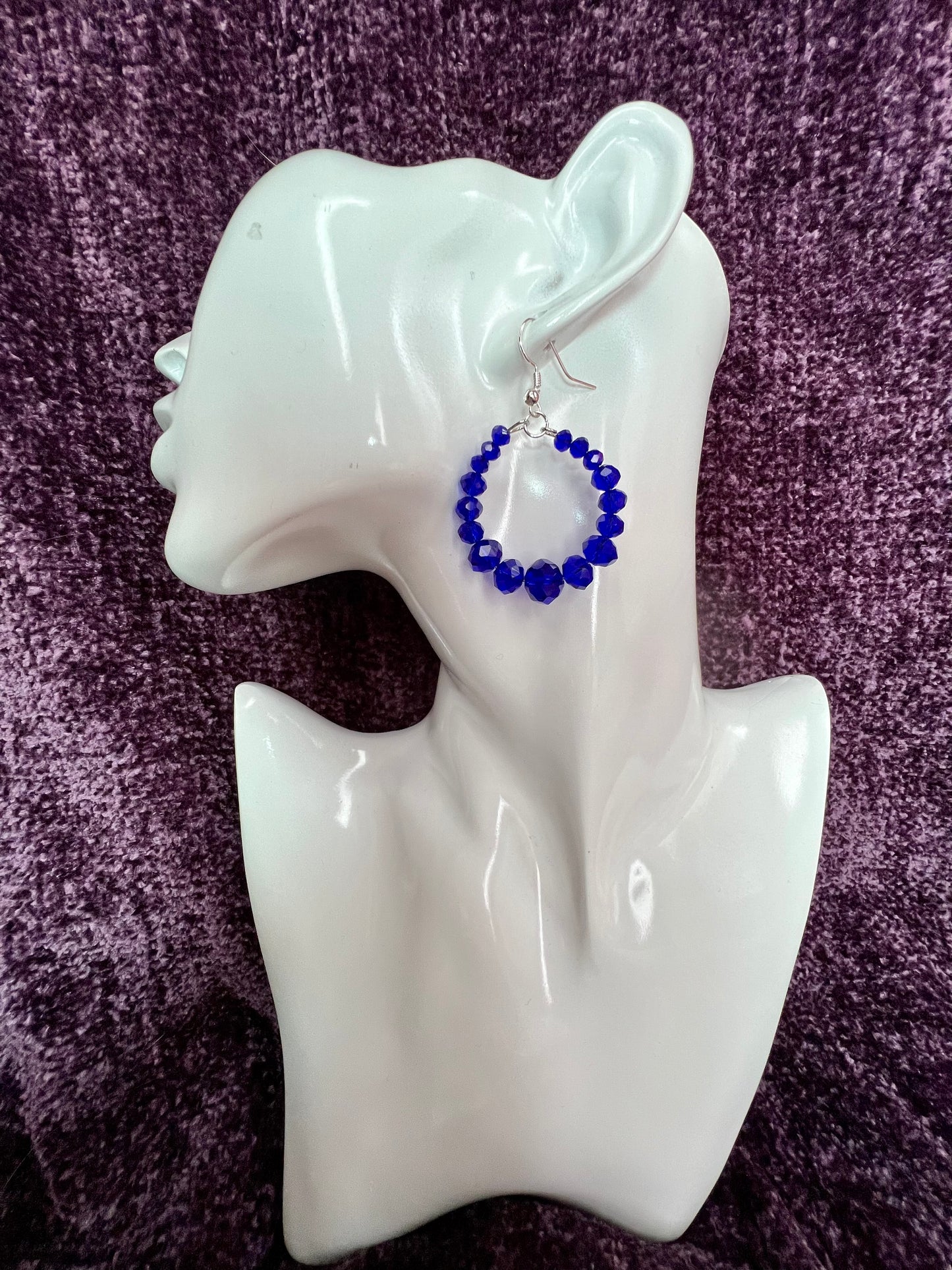 Earrings- Silver plated metal hoops with blue crystals.