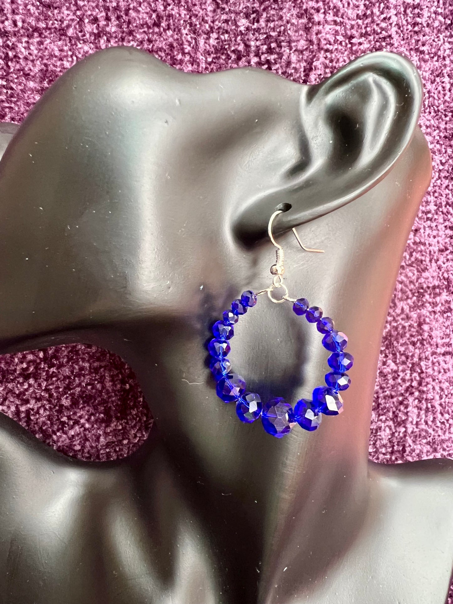 Earrings- Silver plated metal hoops with blue crystals.