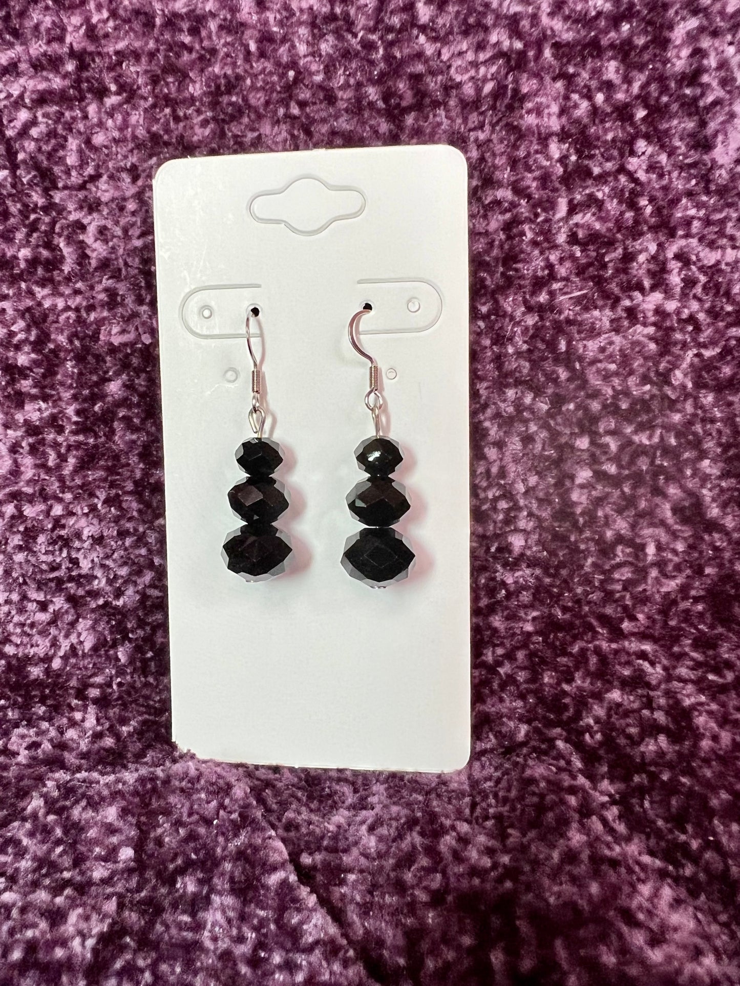 Earrings- Stainless steel ear hooks, silver plated metal with opaque black crystals.