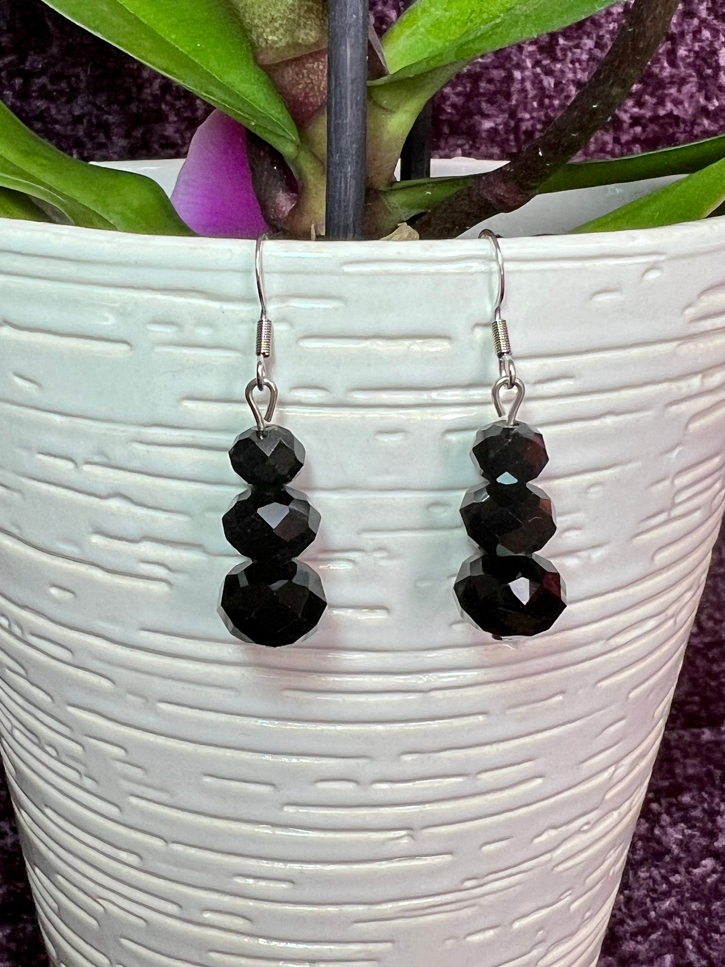 Earrings- Stainless steel ear hooks, silver plated metal with opaque black crystals.