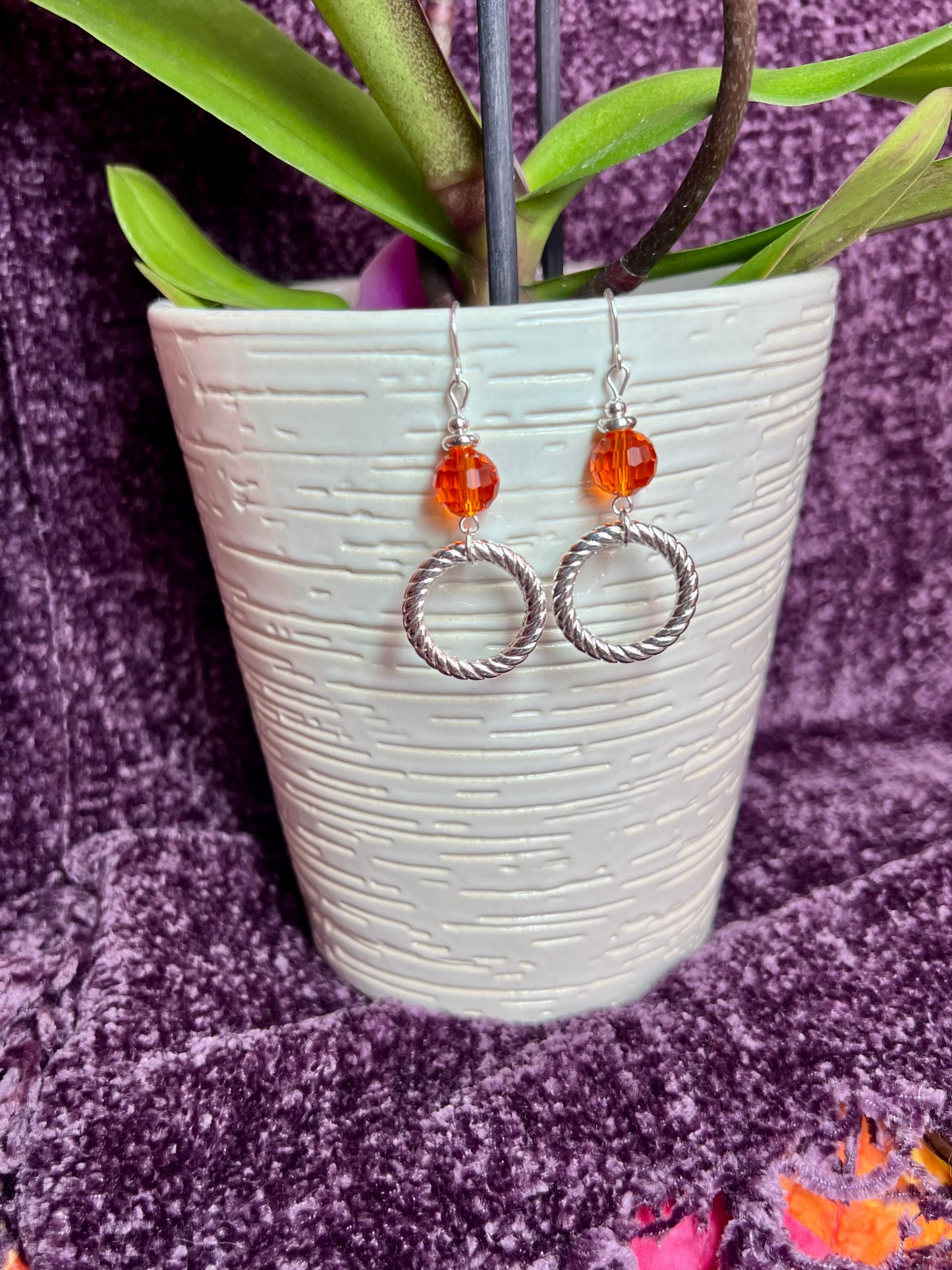 Earrings- Silver plated metal with orange crystal.