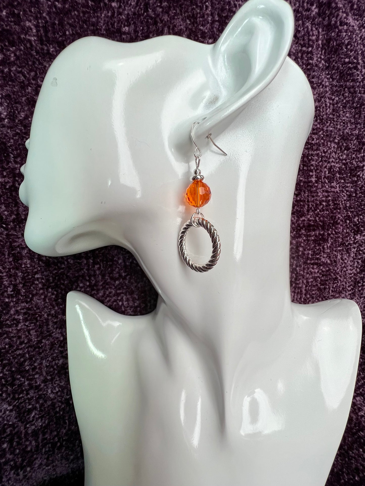 Earrings- Silver plated metal with orange crystal.
