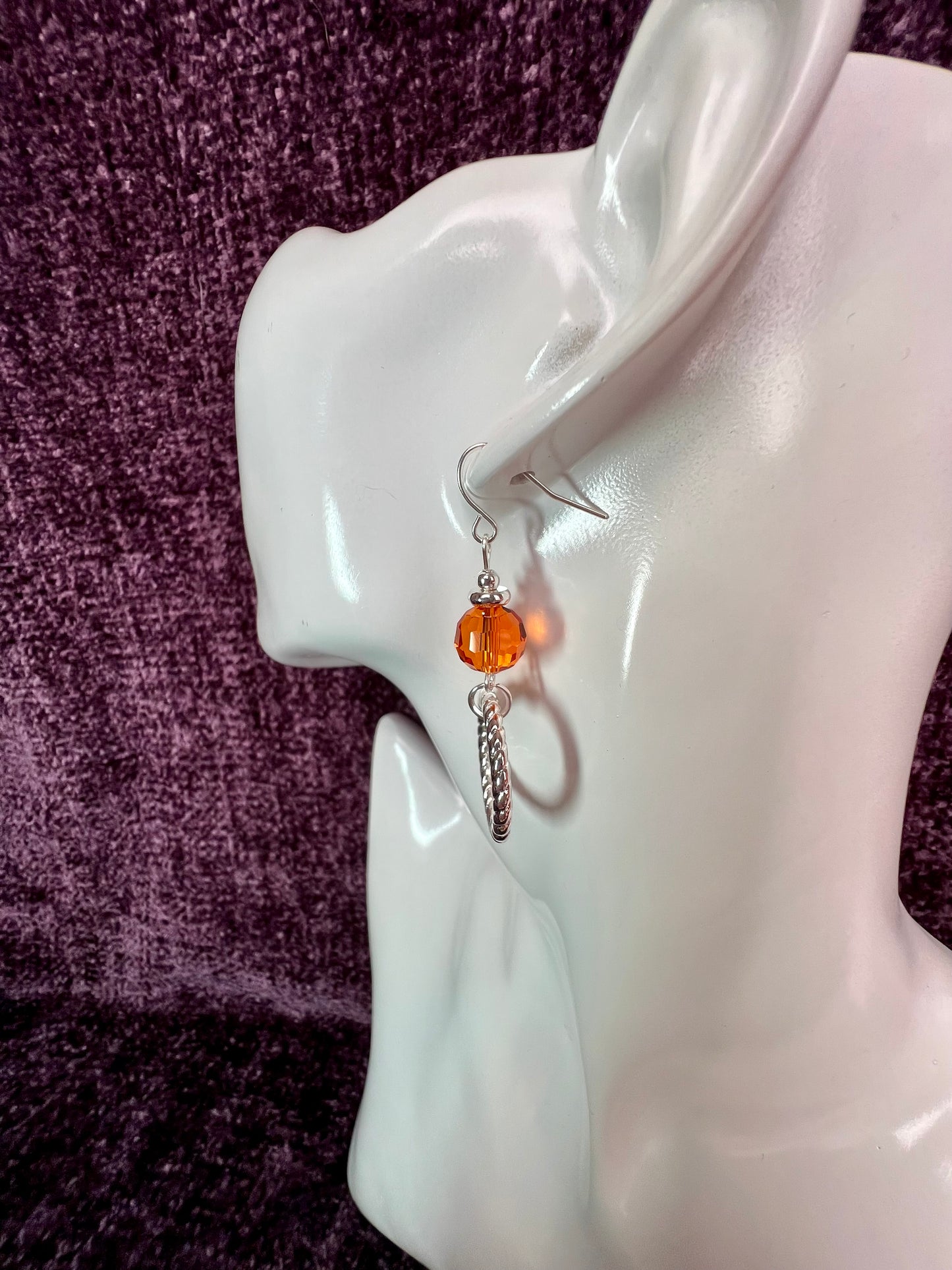 Earrings- Silver plated metal with orange crystal.