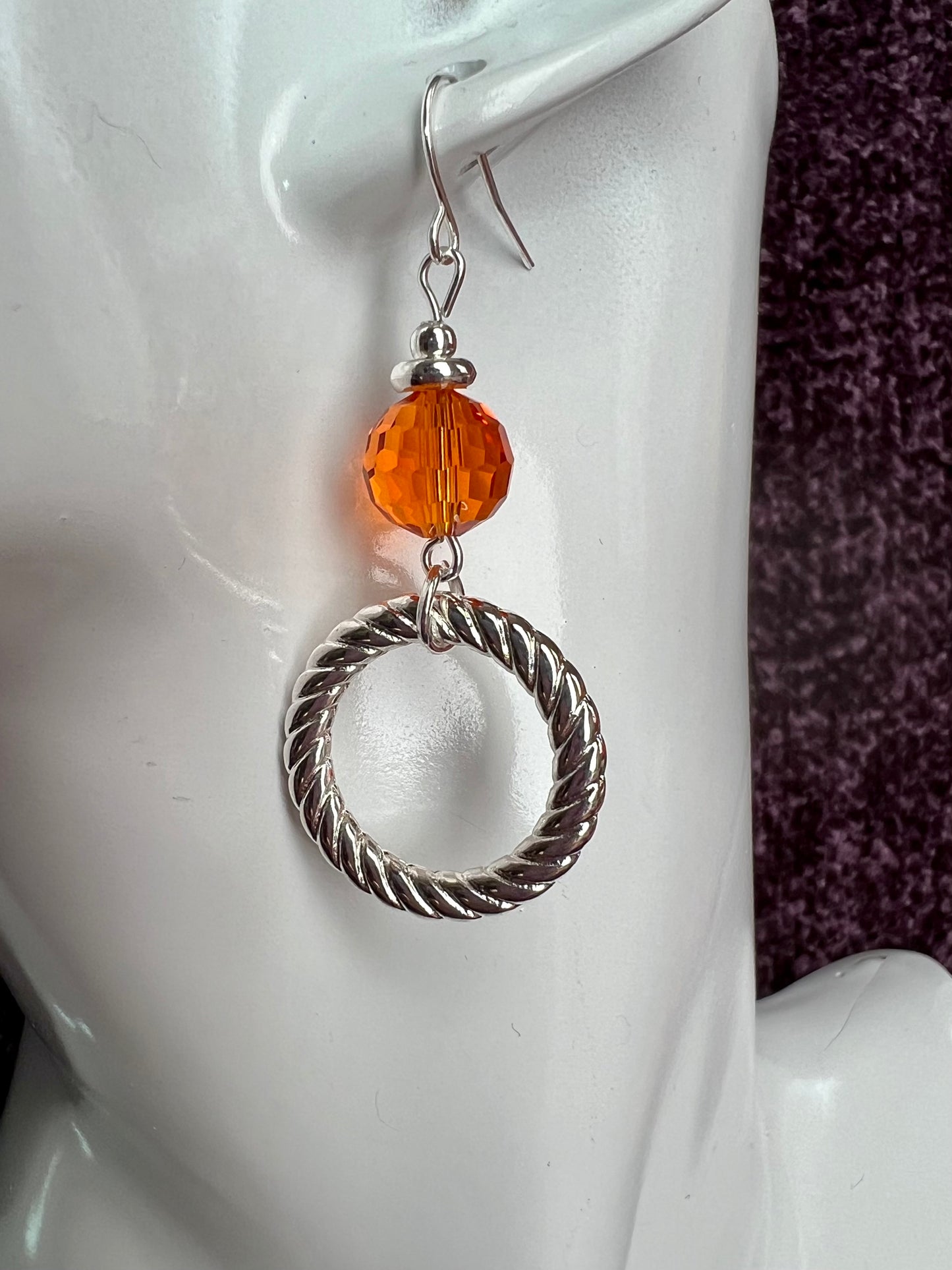 Earrings- Silver plated metal with orange crystal.