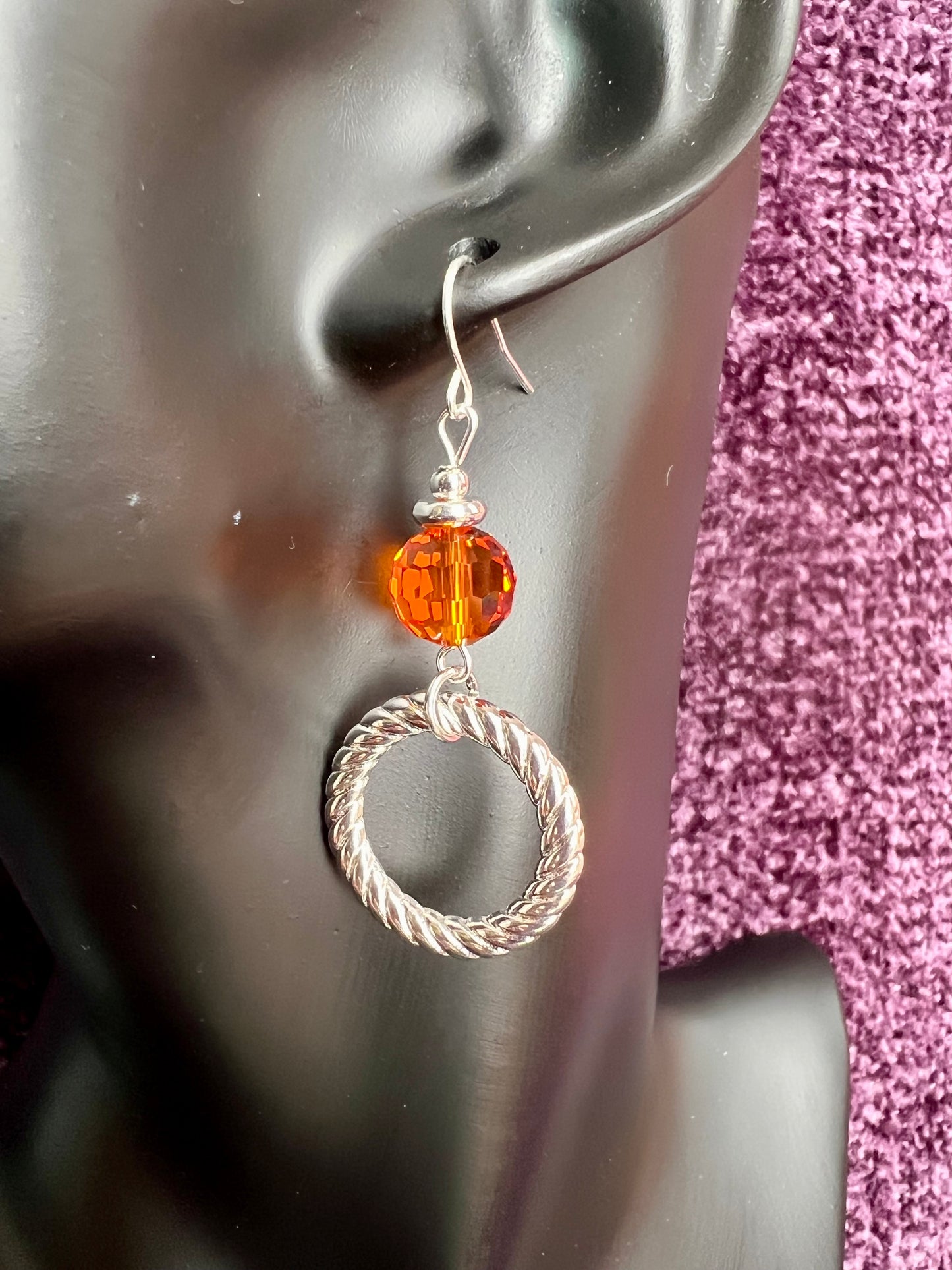 Earrings- Silver plated metal with orange crystal.