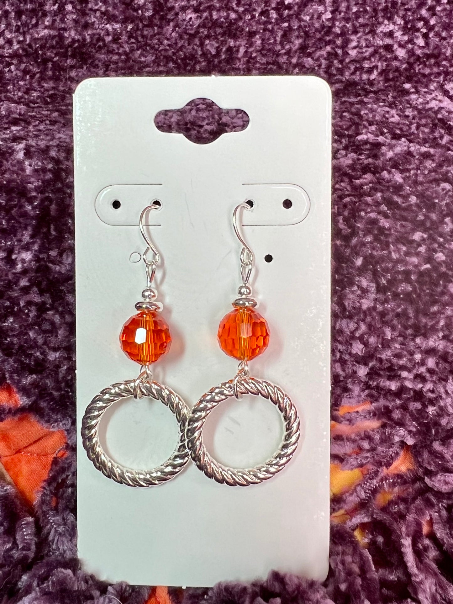 Earrings- Silver plated metal with orange crystal.