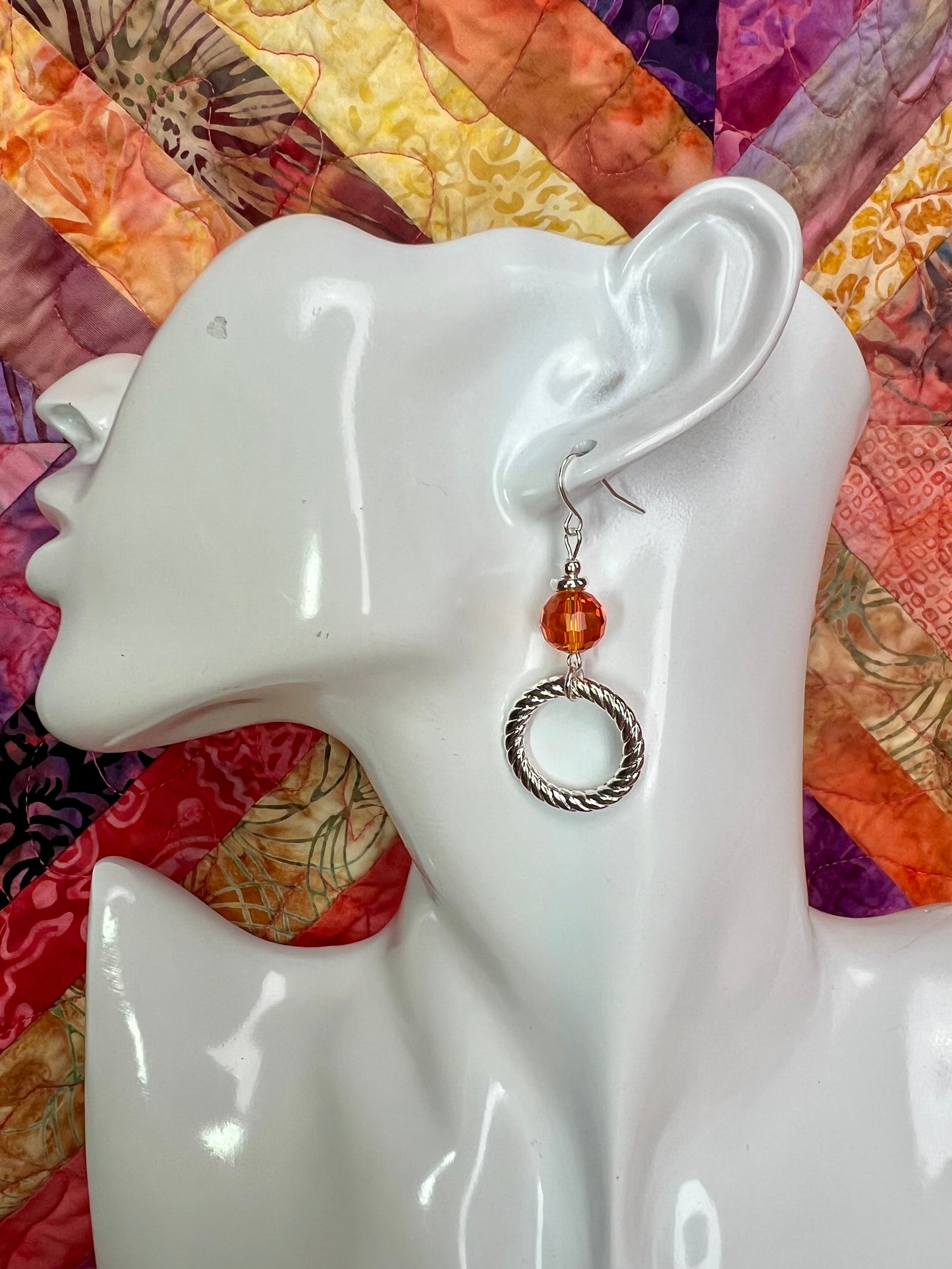 Earrings- Silver plated metal with orange crystal.