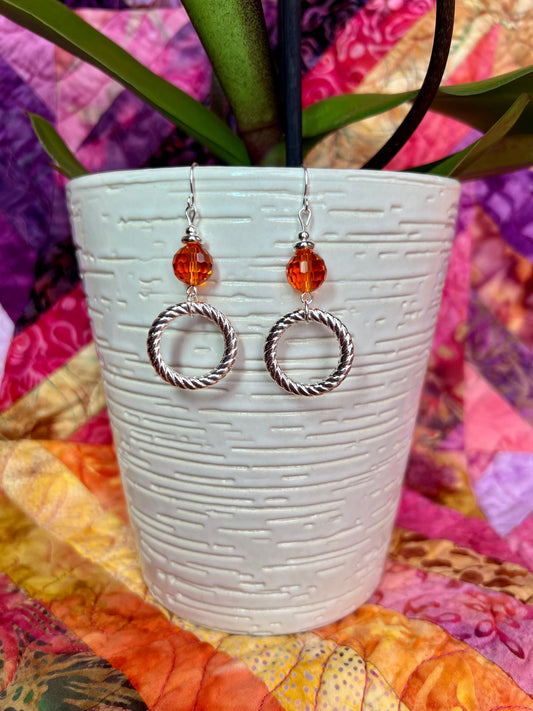 Earrings- Silver plated metal with orange crystal.