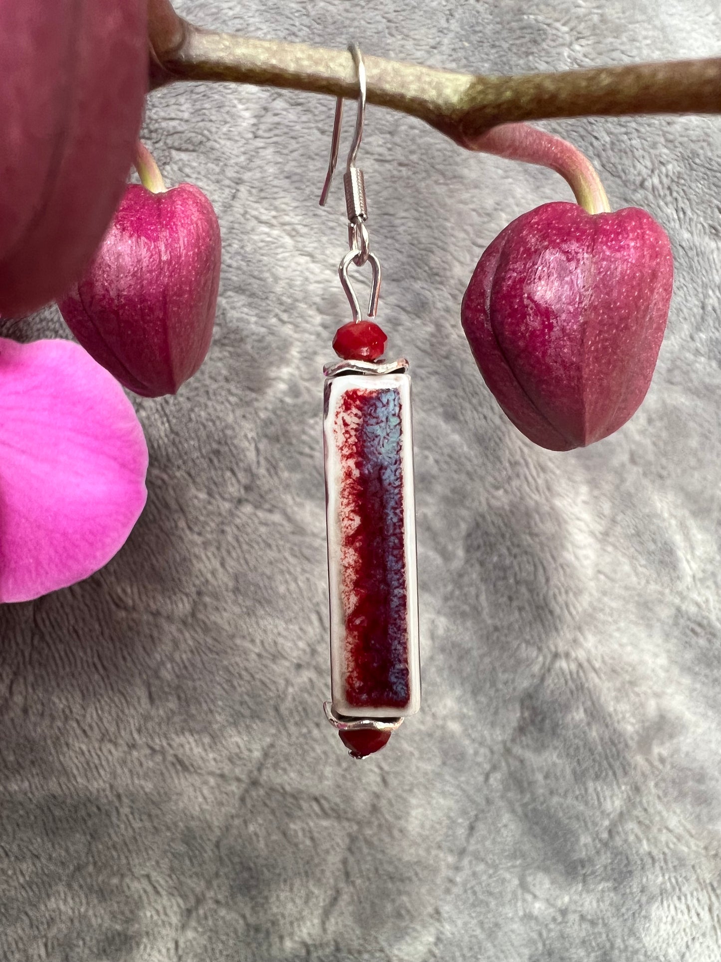 Earrings- Stainless steel ear hooks, red crystals, and ceramic rectangular tube beads in red and blue glaze.