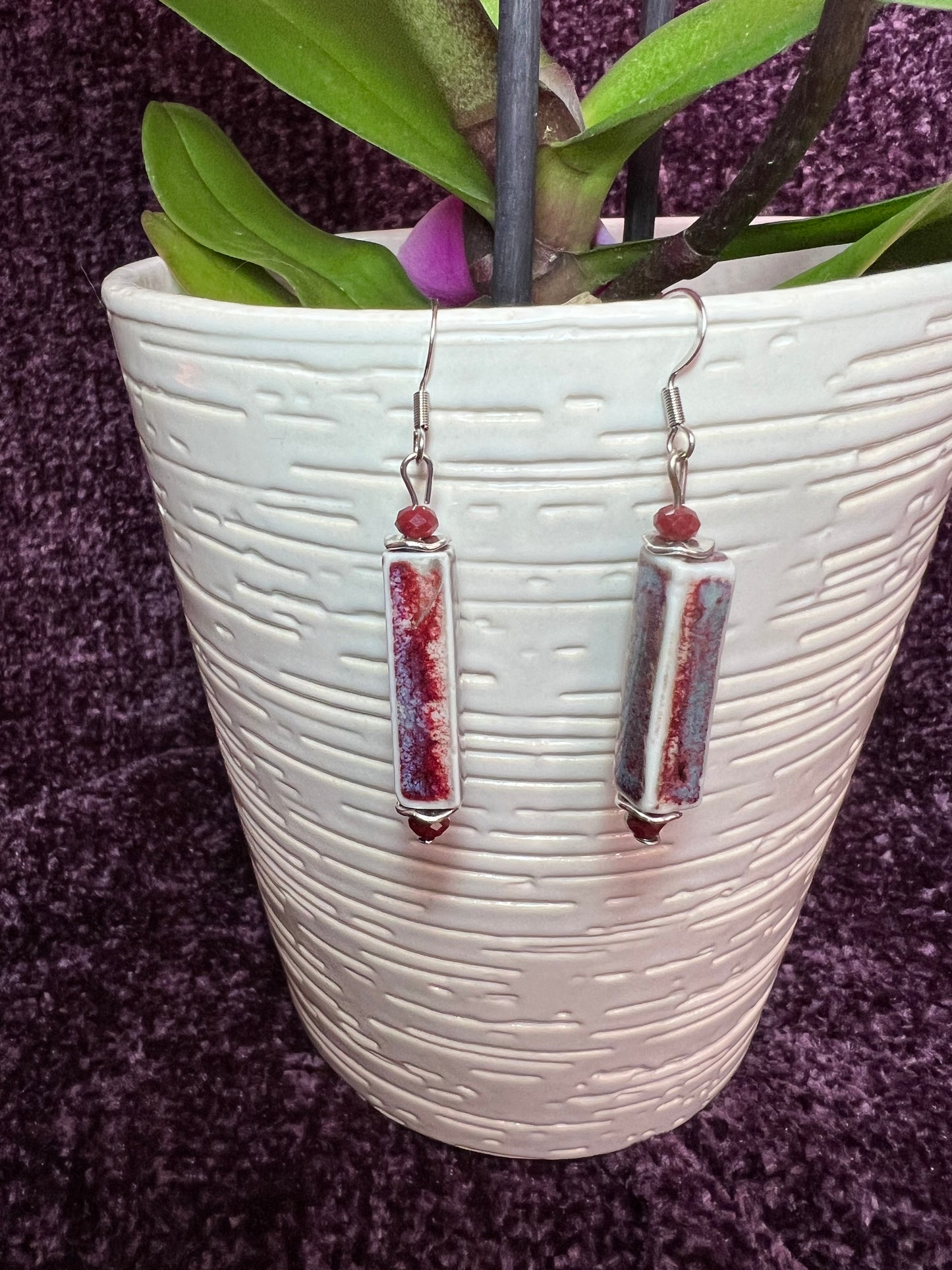 Earrings- Stainless steel ear hooks, red crystals, and ceramic rectangular tube beads in red and blue glaze.