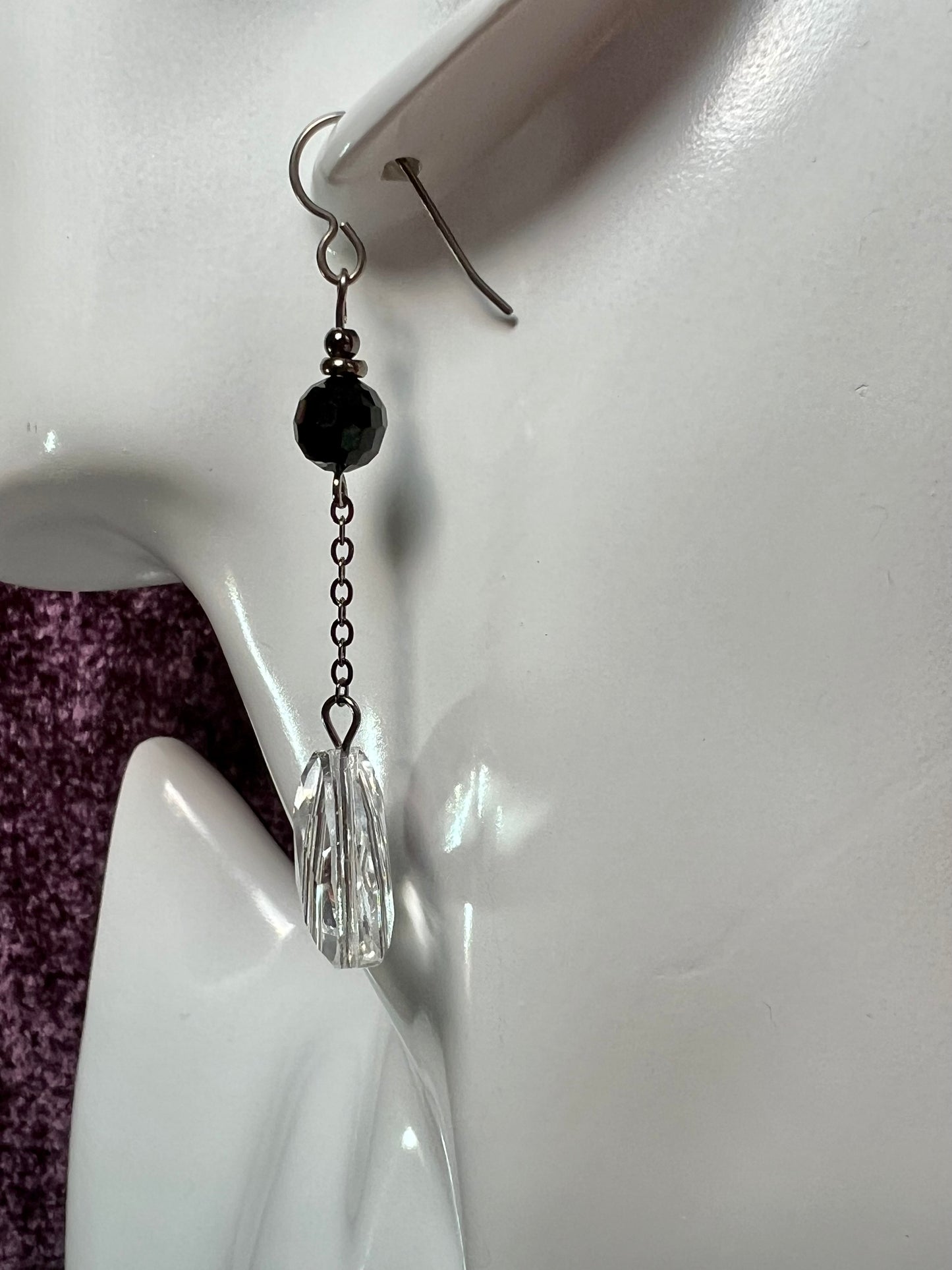 Earrings- Titanium ear hooks, gunmetal plated metal, opaque black round crystal, and trillion shaped crystals.