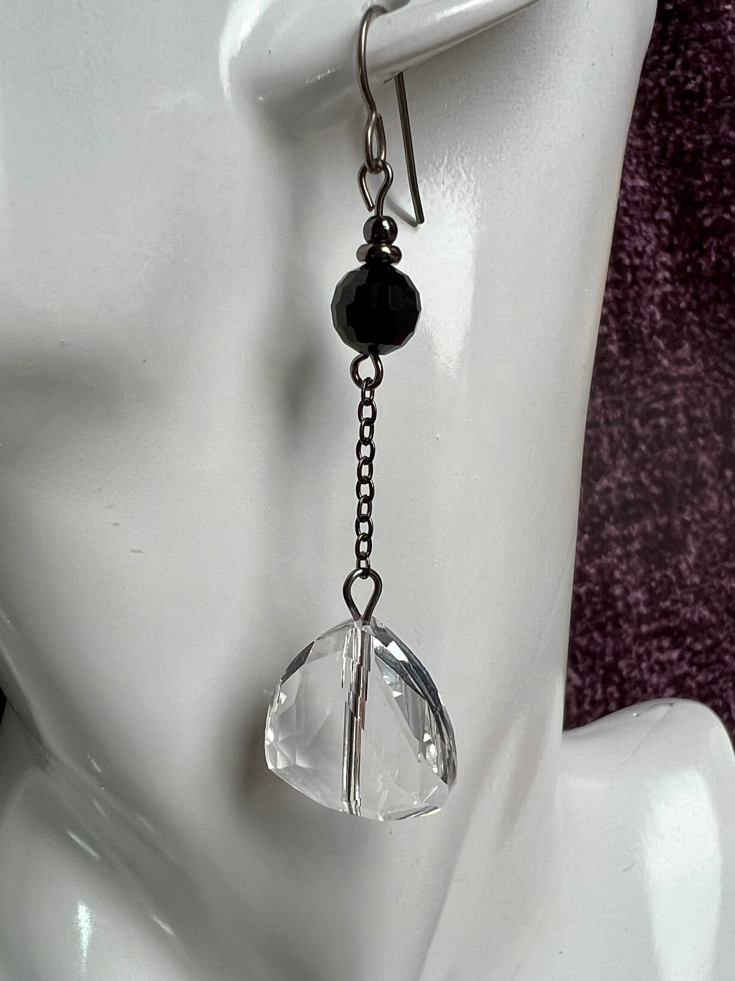 Earrings- Titanium ear hooks, gunmetal plated metal, opaque black round crystal, and trillion shaped crystals.