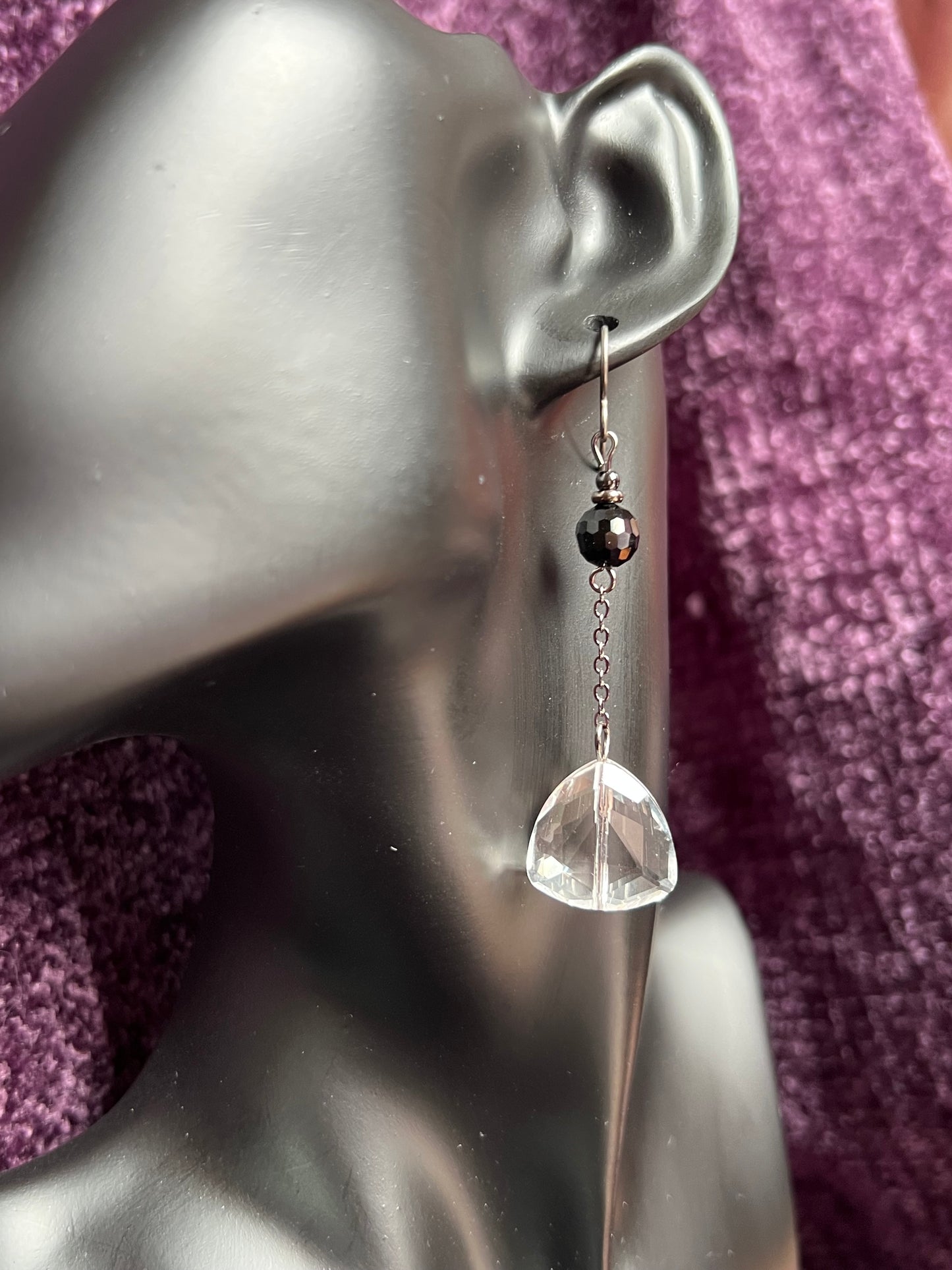 Earrings- Titanium ear hooks, gunmetal plated metal, opaque black round crystal, and trillion shaped crystals.