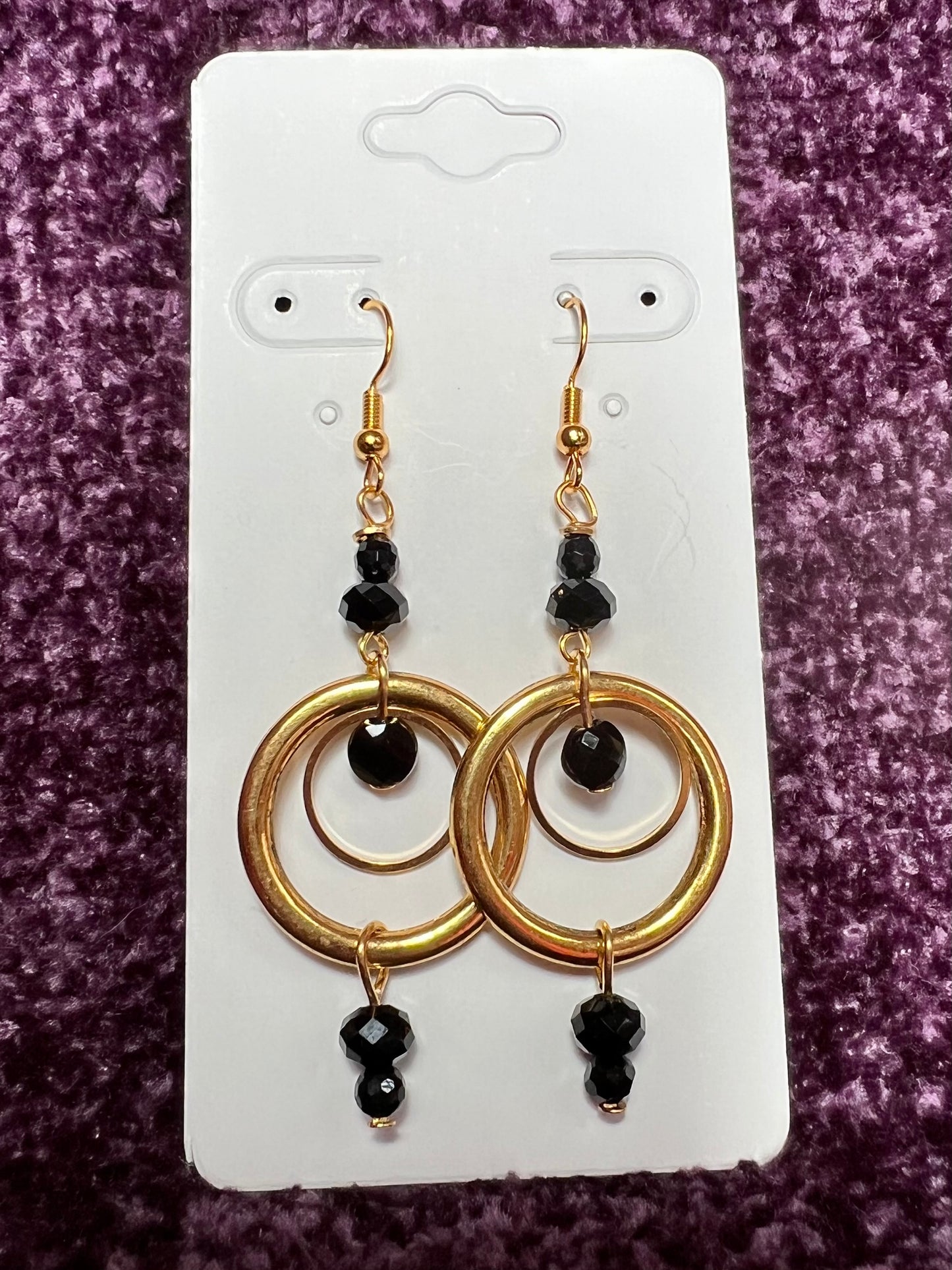 Earrings- Antiqued gold plated stainless steel ear hooks and metal hoops with opaque black crystals.