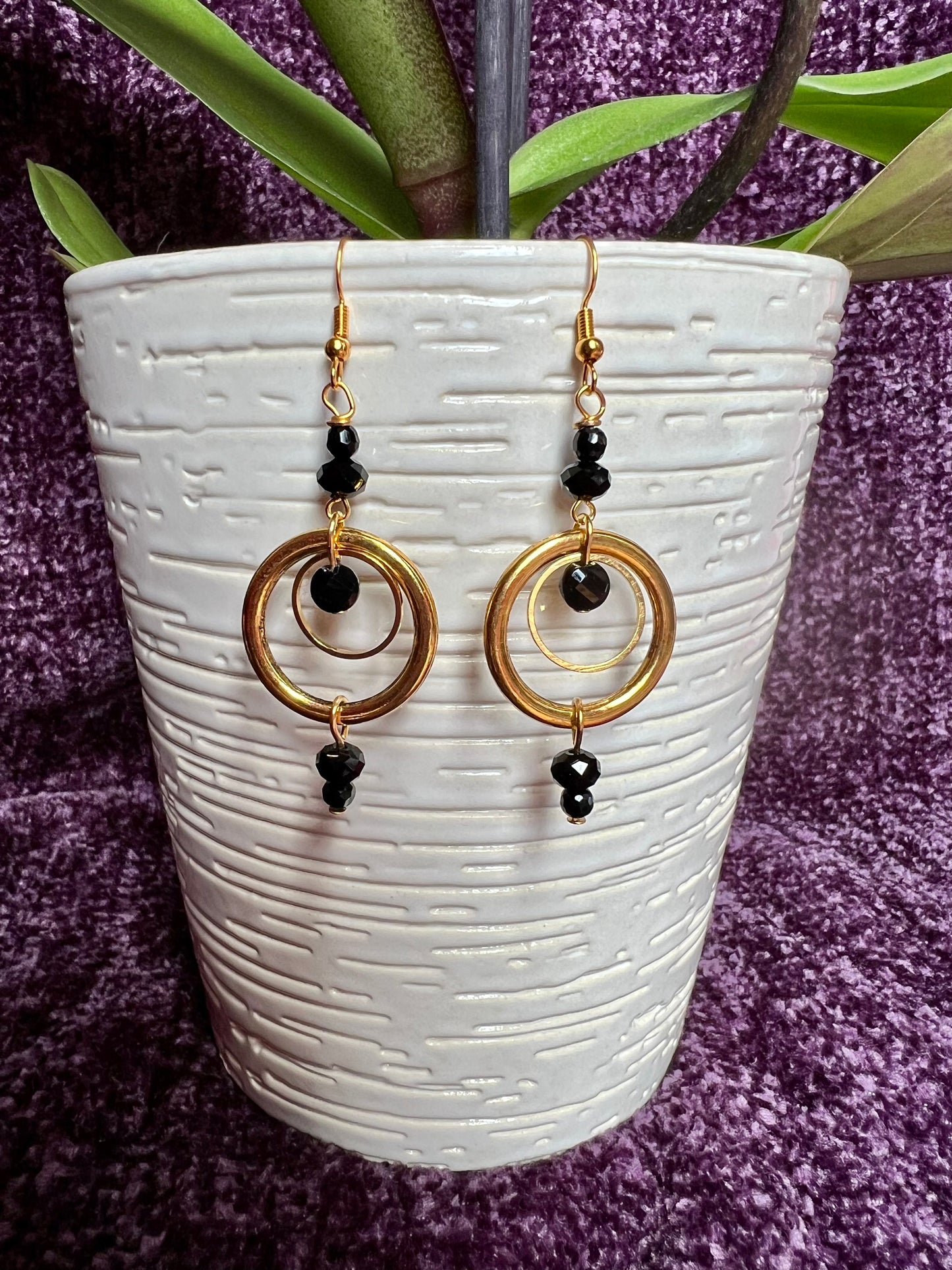 Earrings- Antiqued gold plated stainless steel ear hooks and metal hoops with opaque black crystals.