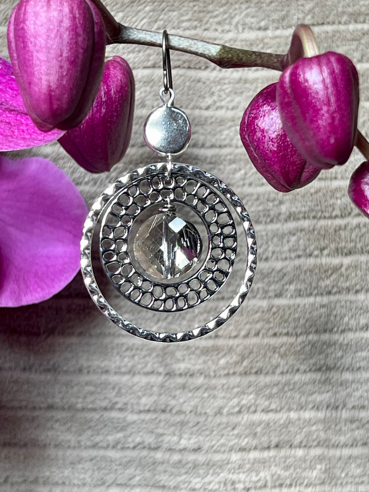 Earrings- Titanium ear hooks with silver and gunmetal plated metal paired with a coin shaped crystal.