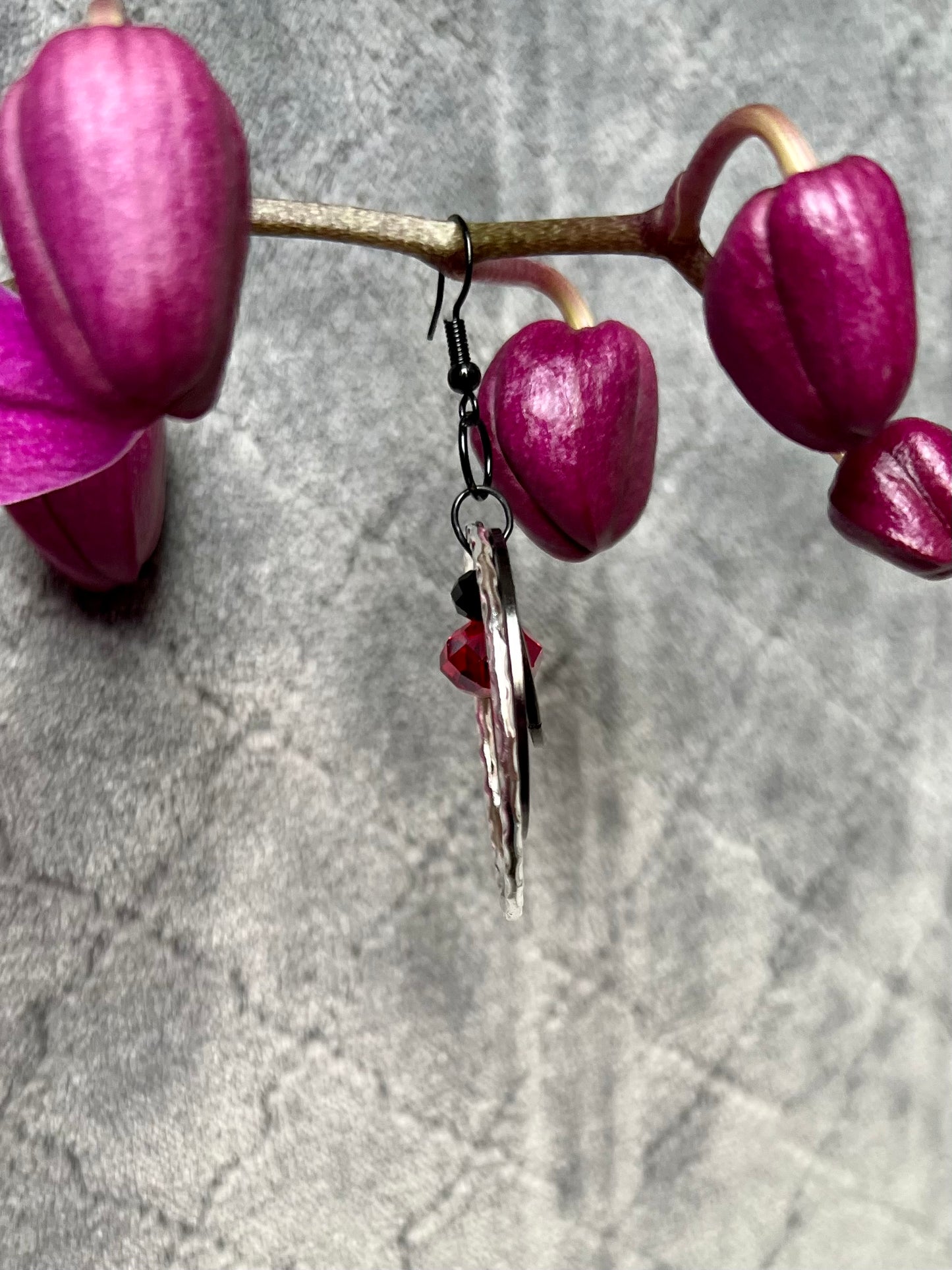 Earrings- Black coated stainless steel ear hooks with gunmetal and silver hoops. Red and black crystals.