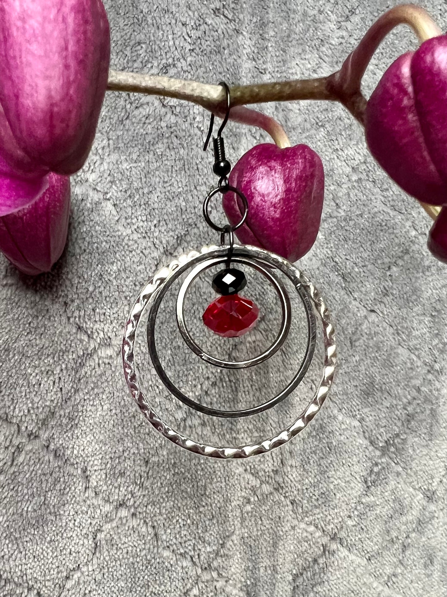 Earrings- Black coated stainless steel ear hooks with gunmetal and silver hoops. Red and black crystals.