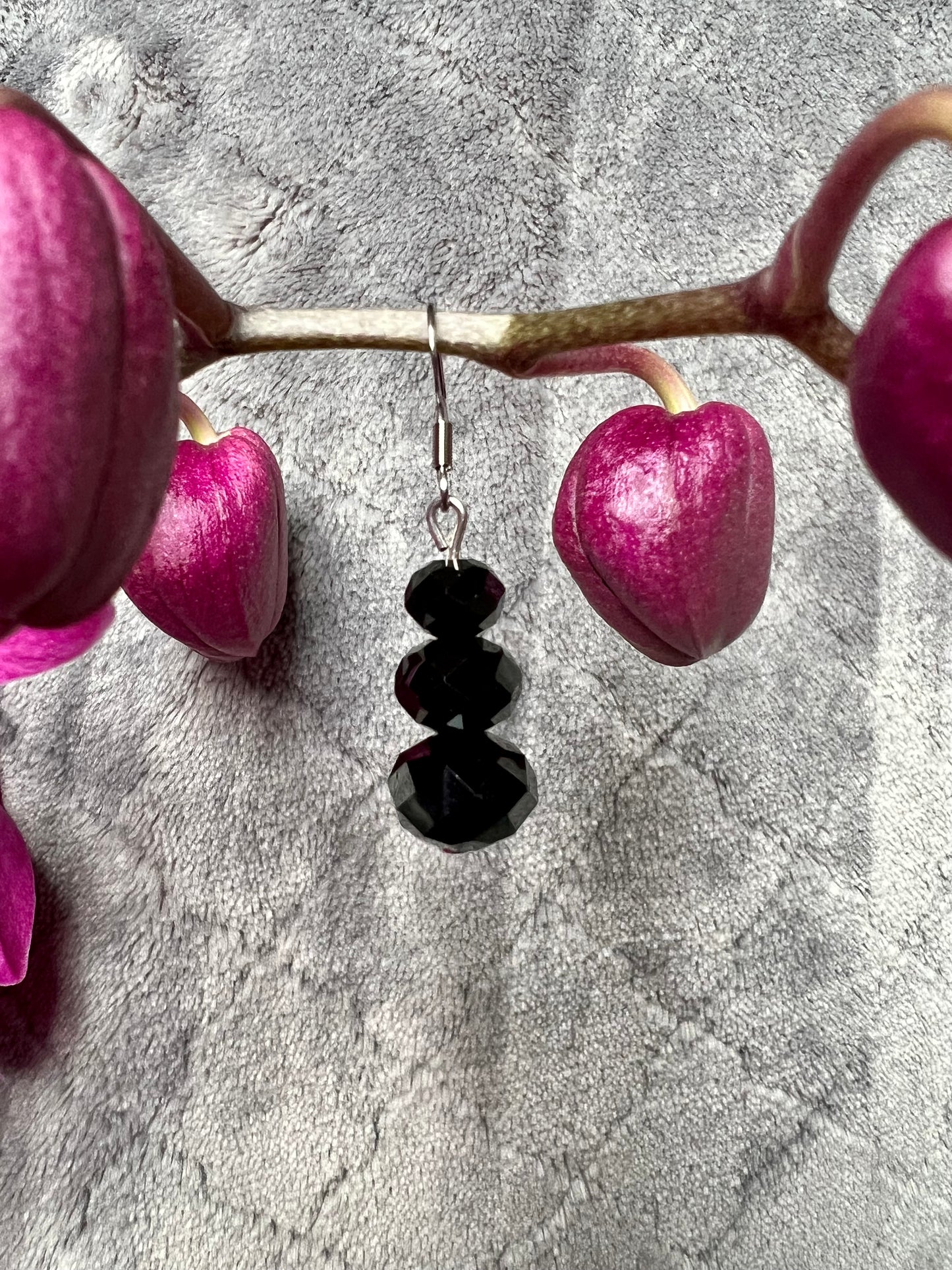 Earrings- Stainless steel ear hooks, silver plated metal with opaque black crystals.